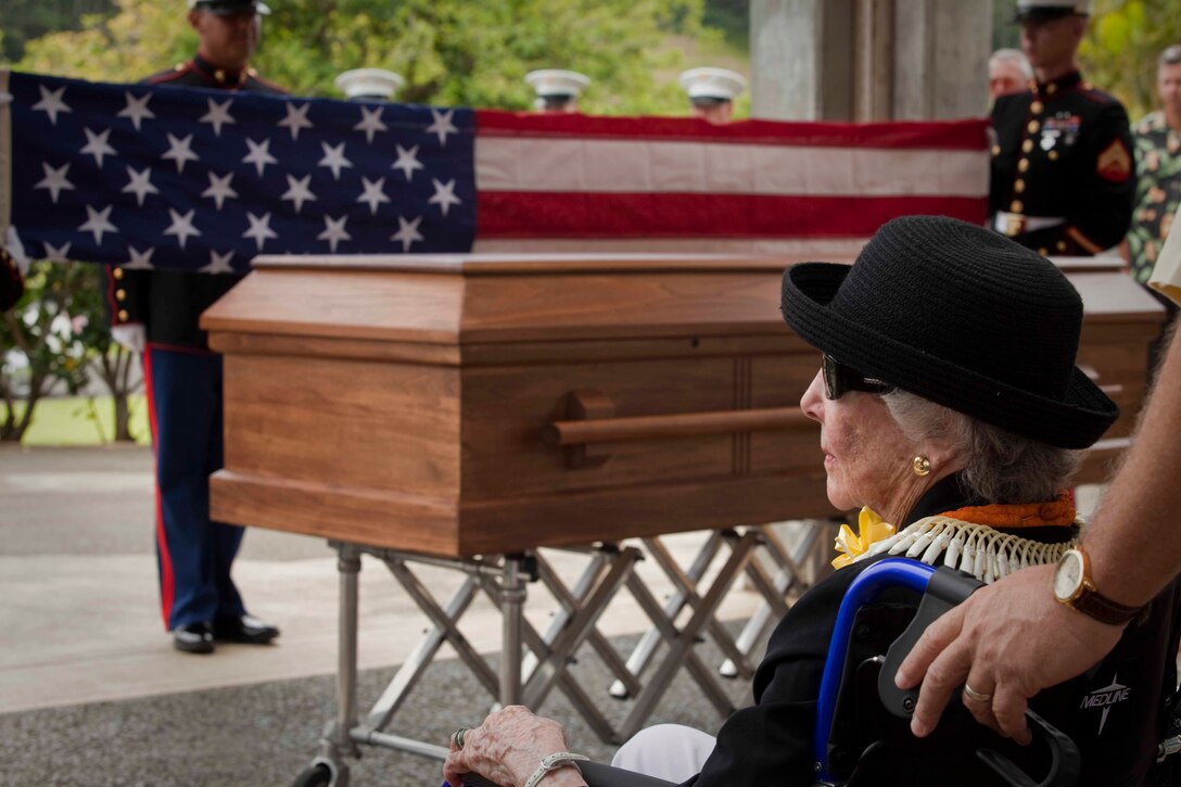 Virginia Ireland, the widow of retired Col. Julius Wirth "Buck" Ireland, watches as a Marine Corps burial detail performs full military honors for her husband during his funeral at the Hawaii State Veterans Cemetery in Kaneohe, Hawaii, Aug. 9. The late Col. Ireland, a Marine F4U Corsair ace pilot credited with shooting down six enemy planes during aerial combat in World War II, earned three Distinguished Flying Crosses, 10 Air Medals, and a Letter of Commendation with Combat "V" during the war. He flew combat missions in 1944 with Marine Fighter Squadron 211 in the Rabaul, Solomons, and Bismarck Archipelago Islands areas, and with VMF-233 in the Ryukyus. After flying jets in the Korean War with VMF-324, he commanded the Marine Helicopter Task Unit in Vietnam in 1962, operating under combat conditions in Soc Trang and Da Nang. Ireland retired in February 1967 after 28 years of military service.