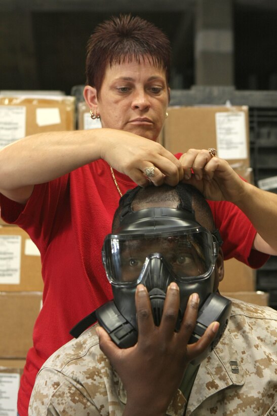 Captain Tito M. Jones, 22nd Marine Expeditionary Unit's anti-terrorist/force protection officer and Anderson, S.C., native, gets sized by Jenni Cantrell, a customer store clerk, during a gas-mask exchange aboard Camp Lejeune, N.C., Aug. 9, 2010. The MEU makes history as the first east coast unit in the Marine Corps to receive the upgraded mask, which replaced the M40 mask.