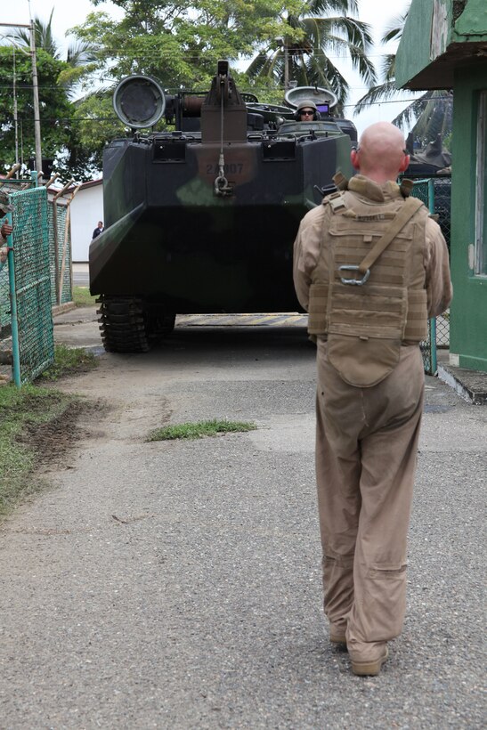Sgt. Brandon T. Russel, native of Omaha, Neb, and crew chief with Company A, 2nd Assault Amphibian Battalion, Ground Combat Element of Special-Purpose Marine Air-Ground Task Force Continuing Promise 2010, guides an amphibious assault vehicle through a gate into Colombian Marine Corps Training Base Covenas in Colombia, Aug. 10, 2010, in preparation for subject matter expert exchanges with Colombian Marines. The Marines’ mission of CP10 is to conduct civil-military operations including subject matter expert exchanges, humanitarian civic assistance and disaster relief to partner nations to the Caribbean, Central and South America. (Marine Corps photo by Cpl. Alicia R. Giron)