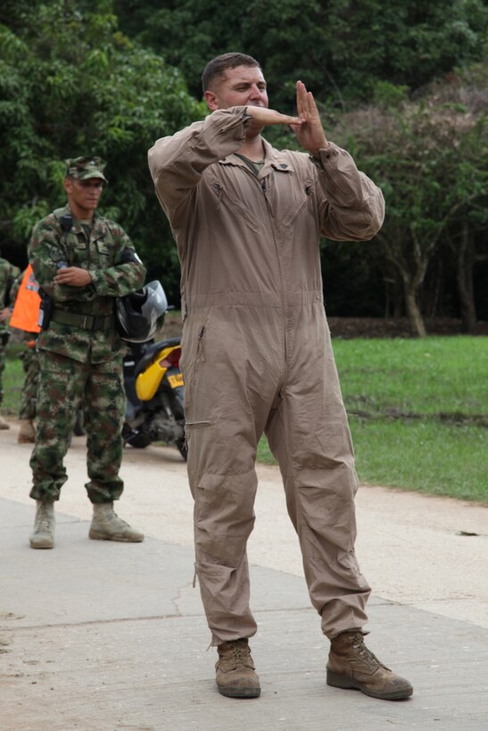 Sgt. Nathan G. Chalman, native of Denver, Colo., and crew chief with Company A, 2nd Assault Amphibian Battalion, Ground Combat Element of Special-Purpose Marine Air-Ground Task Force Continuing Promise 2010, gives hand- and arm- signals to a Marine at Colombian Marine Corps Training Base Covenas in Colombia, Aug. 10, 2010, in preparation for subject matter expert exchanges with Colombian Marines. The mission of CP10 is to conduct civil-military operations including subject matter expert exchanges, humanitarian civic assistance and disaster relief to partner nations to the Caribbean, Central and South America. (Marine Corps photo by Cpl. Alicia R. Giron)