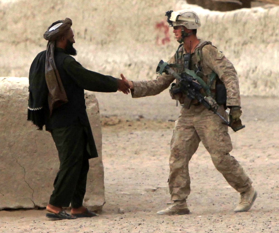 Sgt. Mark Peters, a squad leader with Lima Company, 3rd Battalion, 1st Marine Regiment, engages an Afghan resident during a patrol through Safaar, Afghanistan, Aug. 10, 2010. The Marines of 3/1 are developing relationships with local Afghans, following a clearing operation to rid the area of Taliban presence and intimidation. Peters is from Chicago.