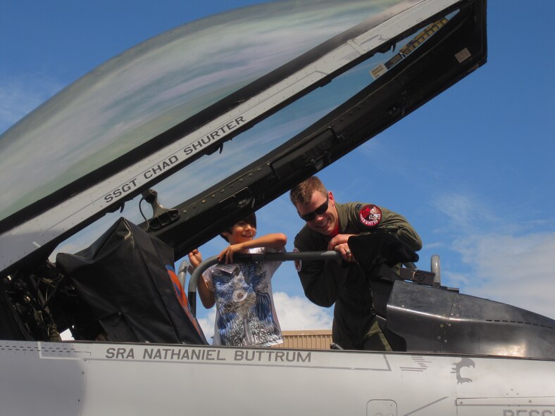 Capt. Ian Billington, 36th Fighter Squadron F-16 pilot, shows Zachary Villa the F-16 cockpit during the ROK-US Family Day Aug. 6. (U.S. Air Force photo by Maj. Denise Kerr)