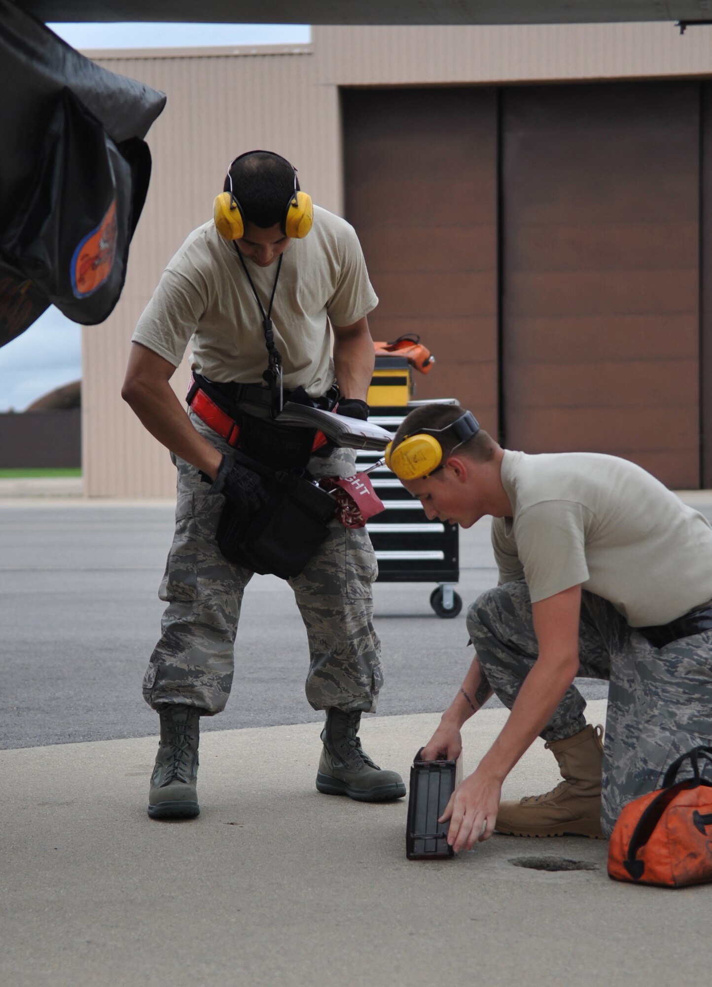 (L-R) Staff Sgt. Kevin McCain and Airman 1st Class Joshua Becker, 51st Aircraft Maintenance Squadron, prepare tools to load an air-to-air missile onto an F-16 fighter jet Aug 6.  Weapons load team members from the 36th and 25th Aircraft Maintenance Units also participated in the quarterly load crew competition. (U.S. Air Force Photo/ Senior Airman Evelyn Chavez)