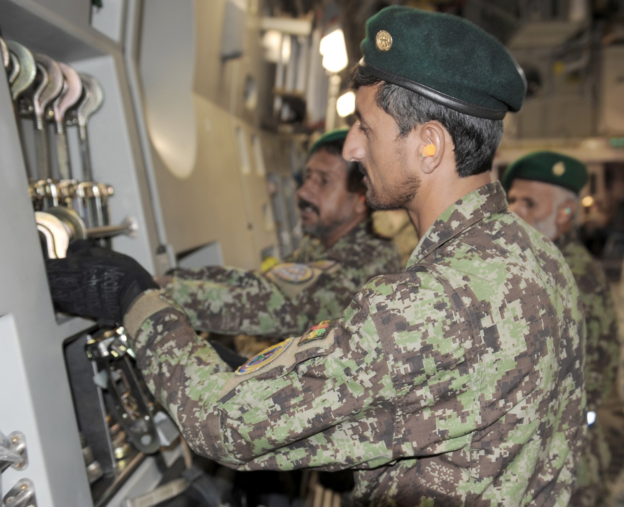 An Afghan aerial porter replaces a tie down aboard a C-17 Globemaster III July 28, 2010, at Bagram Airfield, Afghanistan. (U.S. Air Force photo/Tech. Sgt. Drew Nystrom) 
