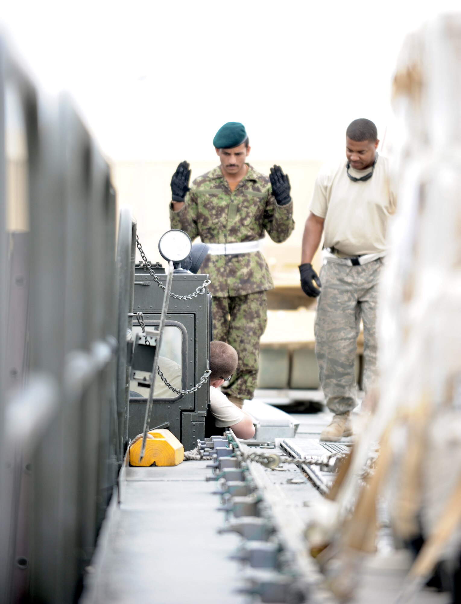 Staff Sgt. Vincent Ross trains an Afghan aerial porter to safely guide a 60,000-pound capable Tunner cargo loader toward its intended cargoJuly 28, 2010, at Bagram Airfield, Afghanistan. Sergeant Ross is an aerial porter with the 455th Expeditionary Aerial Port Squadron deployed from the 69th Aerial Port Squadron at Joint Base Andrews, Md. (U.S. Air Force photo/Tech. Sgt. Drew Nystrom) 