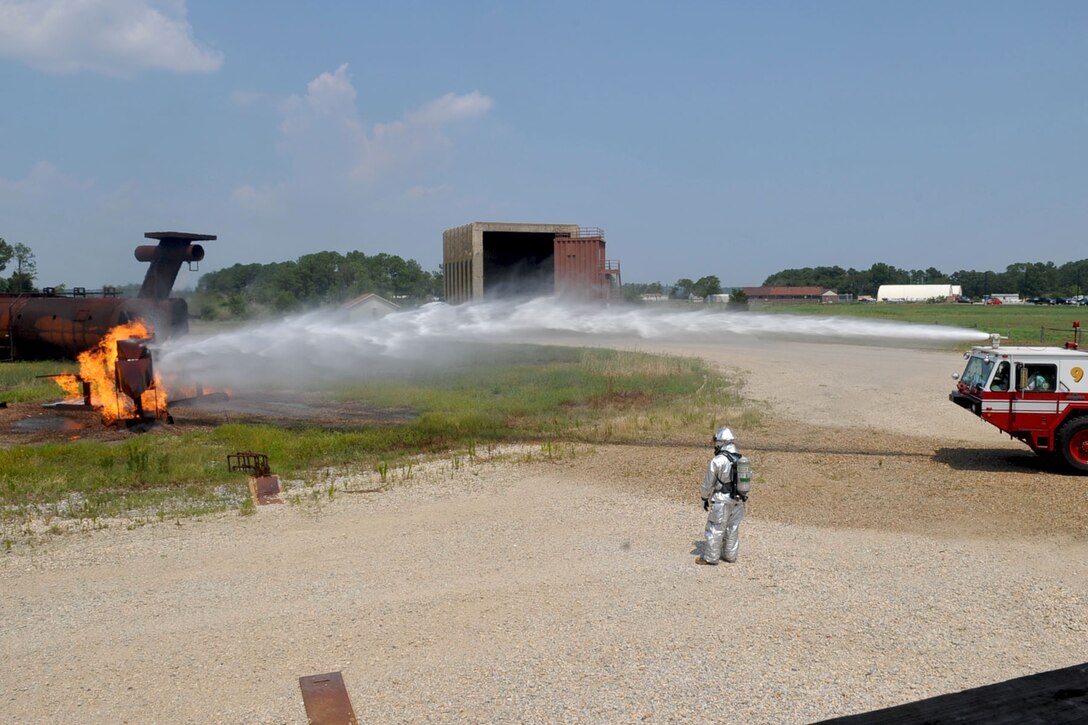 LANGLEY AIR FORCE BASE, Va -- Air Combat Command Chief Master Sgt. Martin Klukas puts out a simulated fire while sitting in the fire truck during a base tour Aug. 10. Chief Klukas toured the base Aug. 9 and 10, interacting with the Airmen of all squadrons to better understand their work force and needs. (U.S. Air Force photo/Staff Sgt. Ashley Hawkins)(RELEASED)
