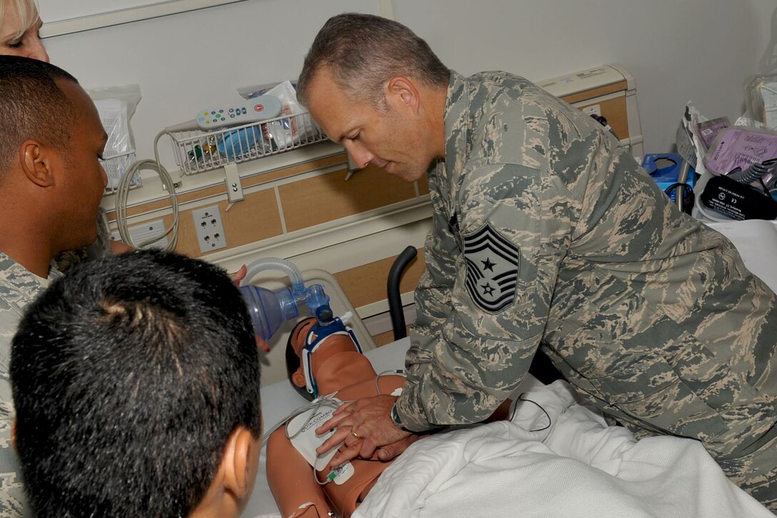 LANGLEY AIR FORCE BASE, Va -- Air Combat Command Chief Master Sgt. Martin Klukas does chest compression to resuscitate a simulated dummy patient during a base tour Aug. 10. The dummy provides doctors and nurses safe training for real life-threatening emergencies. Chief Klukas toured the base Aug. 9 and 10, interacting with the Airmen of all squadrons to better understand their work force and needs. (U.S. Air Force photo/Staff Sgt. Ashley Hawkins)(RELEASED)