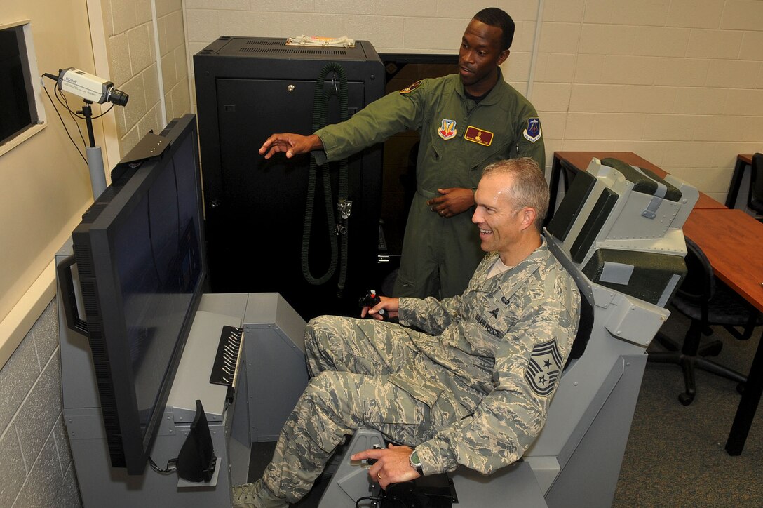 LANGLEY AIR FORCE BASE, Va -- Tech. Sgt. Richard Cadgan, 633d Medical Group Aerospace and Physiology instructor, shows Air Combat Command Chief Master Sgt. Martin Klukas the mechanics of the reduced oxygen breathing device during a base tour Aug. 10. The RBD is a training device pilots use to test their flying altitude. Chief Klukas toured the base Aug. 9 and 10, interacting with the Airmen of all squadrons to better understand their work force and needs. (U.S. Air Force photo/Staff Sgt. Ashley Hawkins)(RELEASED)