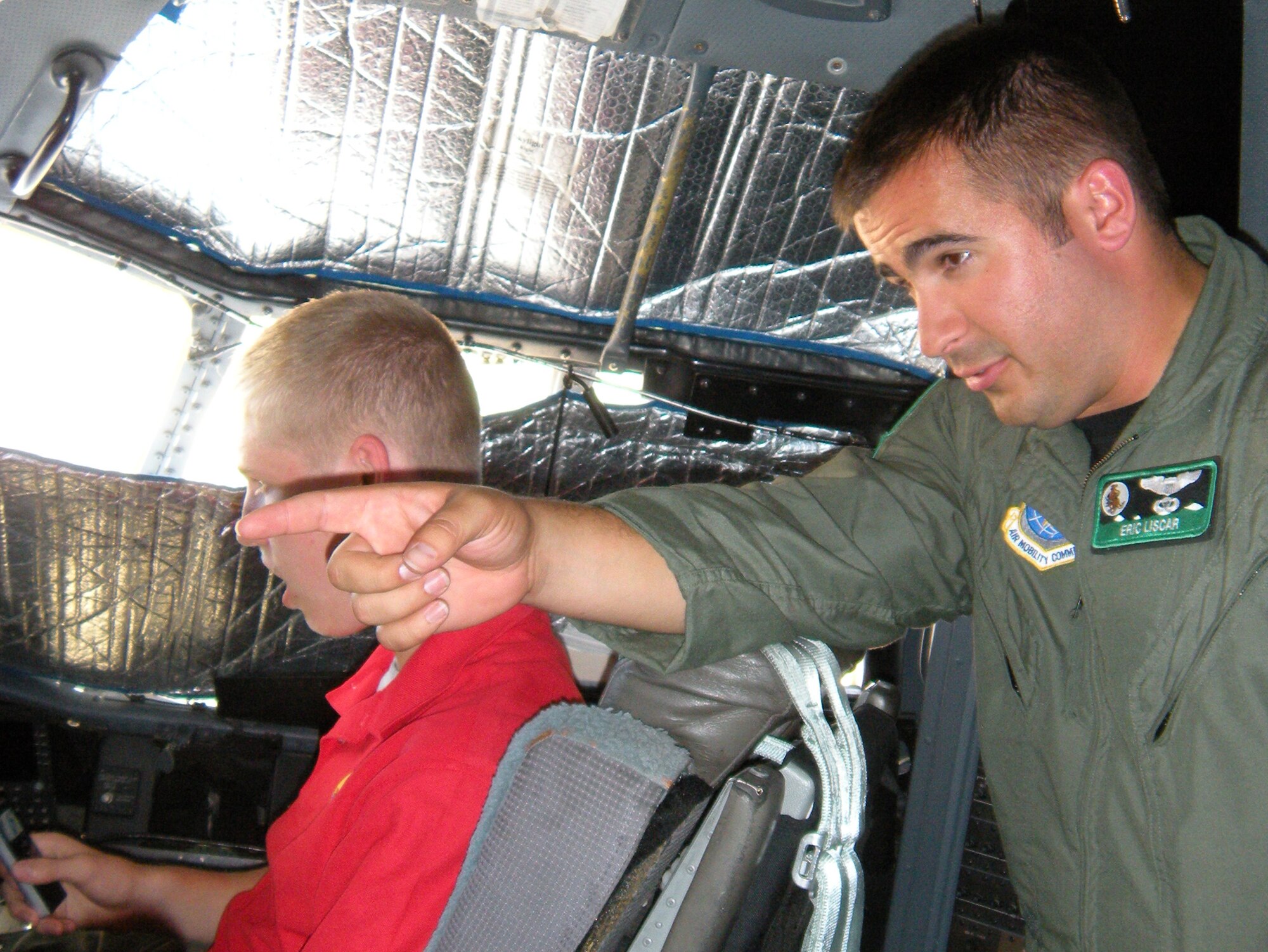 1st Lt. Eric Liscar, an Active Duty C-130 Hercules pilot, highlights different aircraft controls to members of Boy Scout Troop 65 Aug. 4 at Peterson Air Force Base, Colo. The River Forest, Ill.-based scout group visited the Air Force Reserve's 302nd Airlift Wing during their stay in Colorado Springs, Colo. The Boy Scouts were also briefed on the wing's aerial firefighting mission as the 302nd AW is the only AF Reserve organization tasked with supporting the Modular Airborne Firefighting System. Lieutenant Liscar is assigned to the 52nd Airlift Squadron, an Active Duty organization associated with the 302nd AW. (U.S. Air Force photo/Rebekah Williamson)