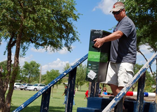 Danny Kernan, an air traffic controller with the 27th Special Operations Support Squadron, walks off the prize stage with a 37-inch HDTV during Cannon Appreciation Day Aug. 6, 2010. Prizes totaling $4,000 were won by Cannon Airmen, their families and civilian workers at Cannon Air Force Base, N.M. (U.S. Air Force photo by 2nd Lt. Stephanie Strine)

