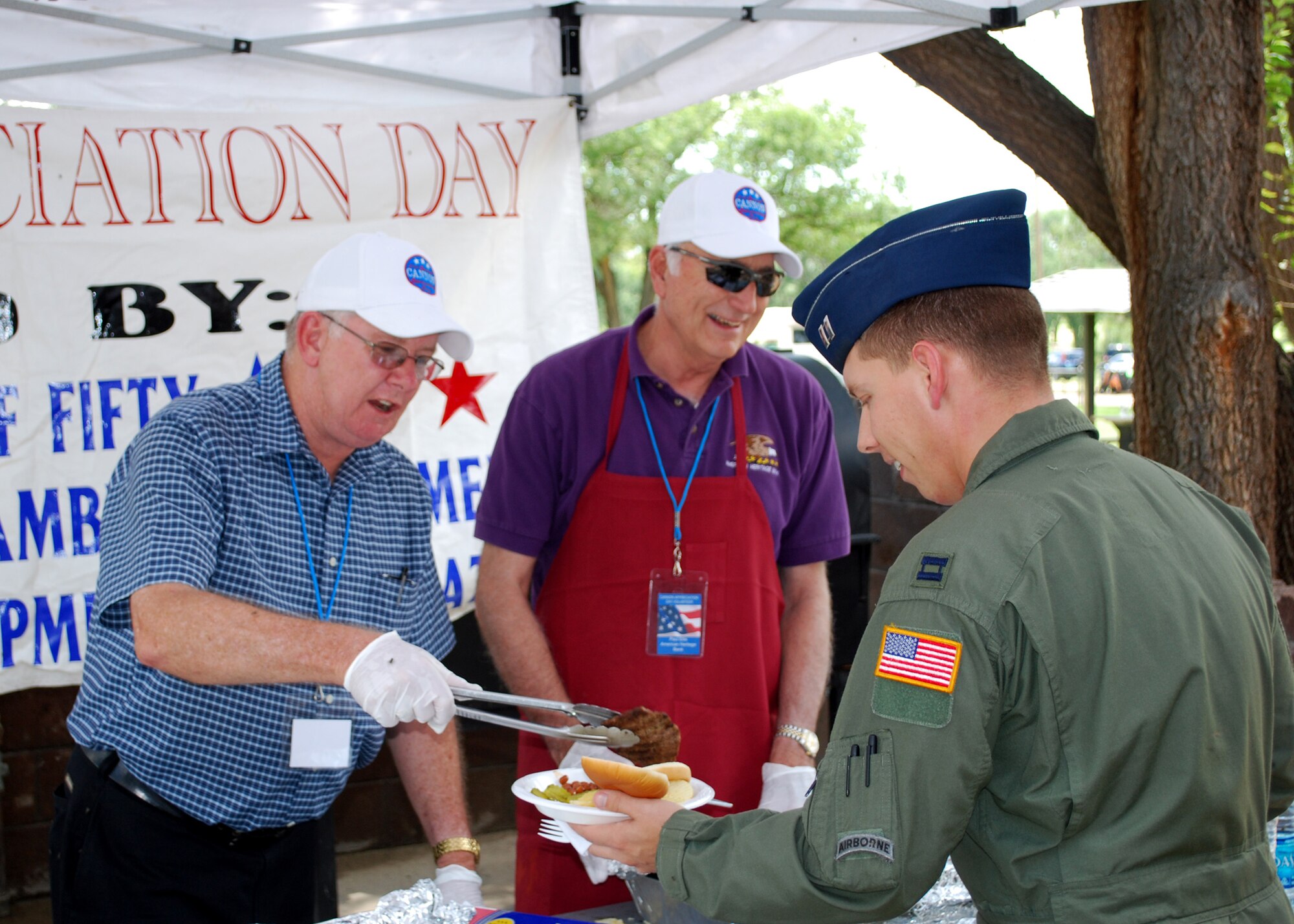 Clovis City Commissioner Chris Bryant (left) and American Heritage Bank Manager Paul Ellis serve burgers to Airmen of the 27th Special Operations Wing at the 21st annual Cannon Appreciation Day  Aug. 6, 2010.  Around 4,000 hamburgers and 3,500 hot dogs were served at the event.  (U.S. Air Force photo by 2nd Lt. Stephanie Strine)