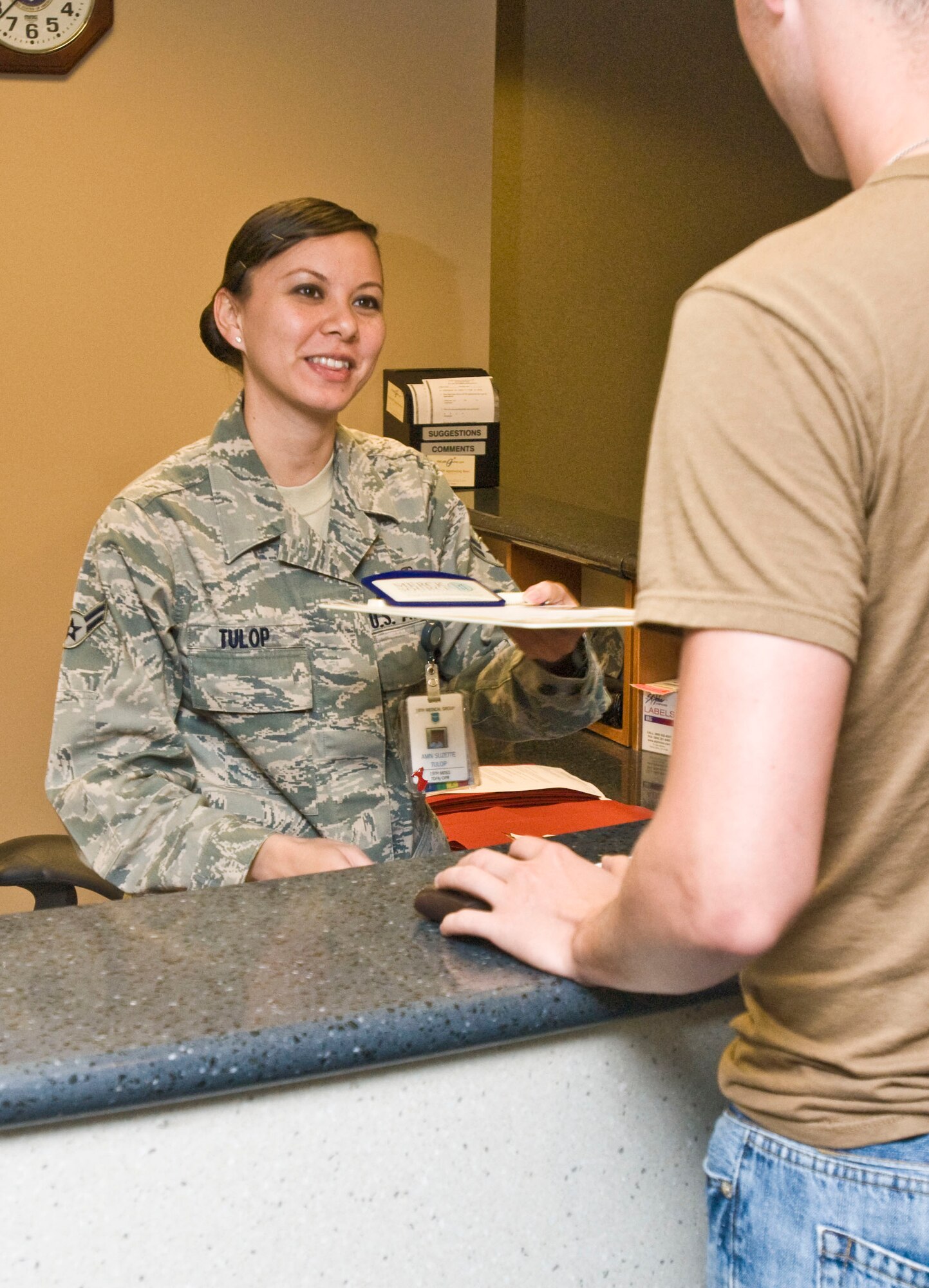 Airman 1st Class Suzette Tulop, 19th Medical Group outpatient records technician, checks in a patient Aug. 6 at the 19th MDG family practice clinic. Airman Tulop was selected to receive the Chiefs' Sharp Troop award for her job performance and volunteer efforts. She augmented squadron members during peak hours, booked approximately 65 appointments and checked in 750 patients in July. Airman Tulop also volunteered her time at the Airman’s Attic in support of Team Little Rock’s junior enlisted members. (U.S. Air Force photo by Staff Sgt. Nestor Cruz)