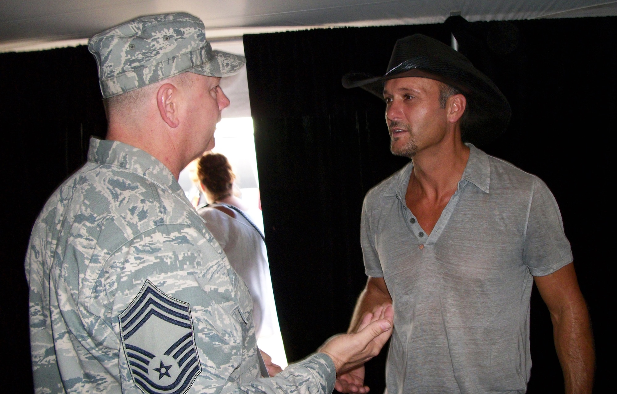 Chief Master Sgt. Vincent Meyer extends his hand to "coin" Tim McGraw before the country music legend opened a concert July 31 in Englewood, Colo. Chief Meyer, the senior recruiter at Peterson Air Force Base, Colo., presented the Air Force Reserve Command recruiting coin to Mr. McGraw as part of his support to the Get-1-Now program. Air Force Reservists can earn prizes and access to events, like the Tim McGraw concert, by referring individuals to AF Reserve recruiters for possible AF Reserve jobs. For more information on the Get-1-Now program, visit www.get1now.us. (Courtesy photo)