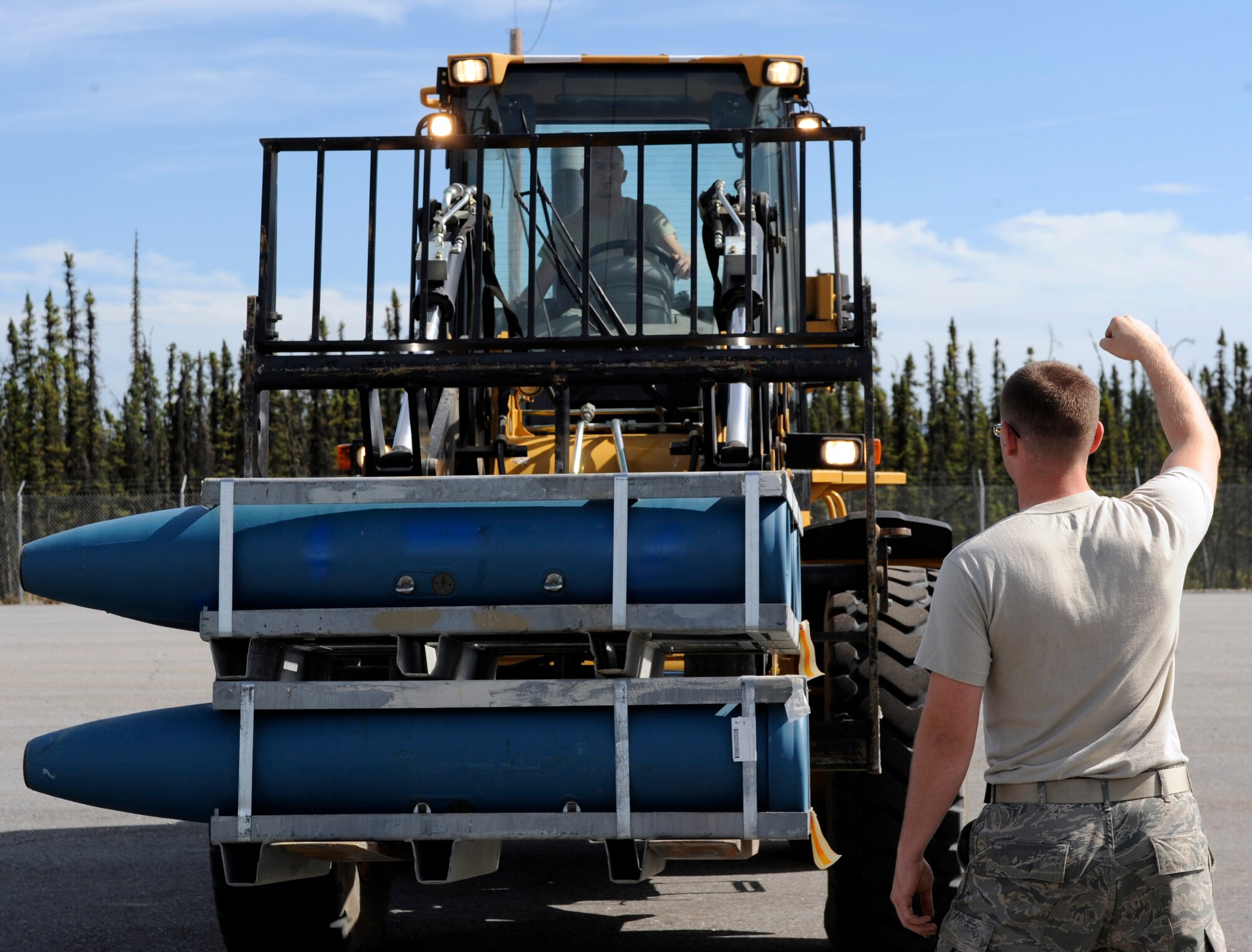 Airmen 1st Class Christopher Lynch and Justin Brossman operate and spot a 10K forklift into position, respectively August 6, 2010 Eielson Air Force Base, Alaska. The Airmen pre-position USMC 1000 lbs. inert bombs in preparation for outbound munitions shipment. The Airmen are munitions storage crewmembers assigned to the 354th Munitions Flight. (U.S. Air Force photo/Senior Airman Willard E. Grande II)