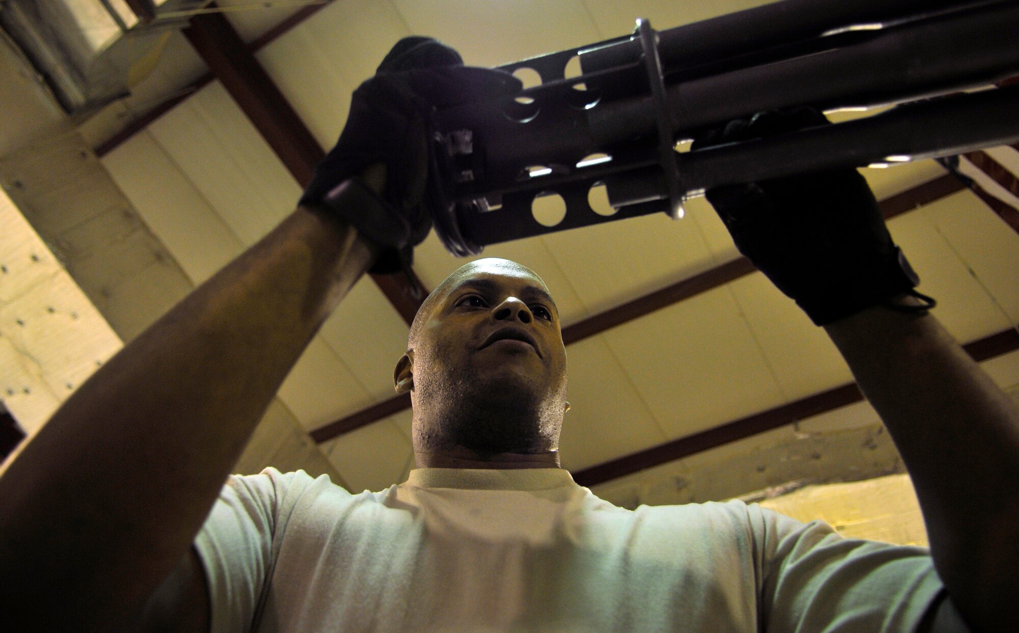 Staff Sgt. Calvin Adger, 332nd Expeditionary Maintenance Squadron Armament Flight specialist, finishes the final step in a M61A1 Gatling-type gun build by sliding the muzzle clamp over the end of the weapon Aug. 6, 2010, Joint Base Balad, Iraq. The weapon provides close range air-to-air and air-to ground combat capabilities to fighter aircraft aircrews. Sergeant Adger, a native of Columbia, S.C., is deployed from the McEntrye Air National Guard Station, S.C. (U.S. Air Force photo/Staff Sgt. Phillip Butterfield)