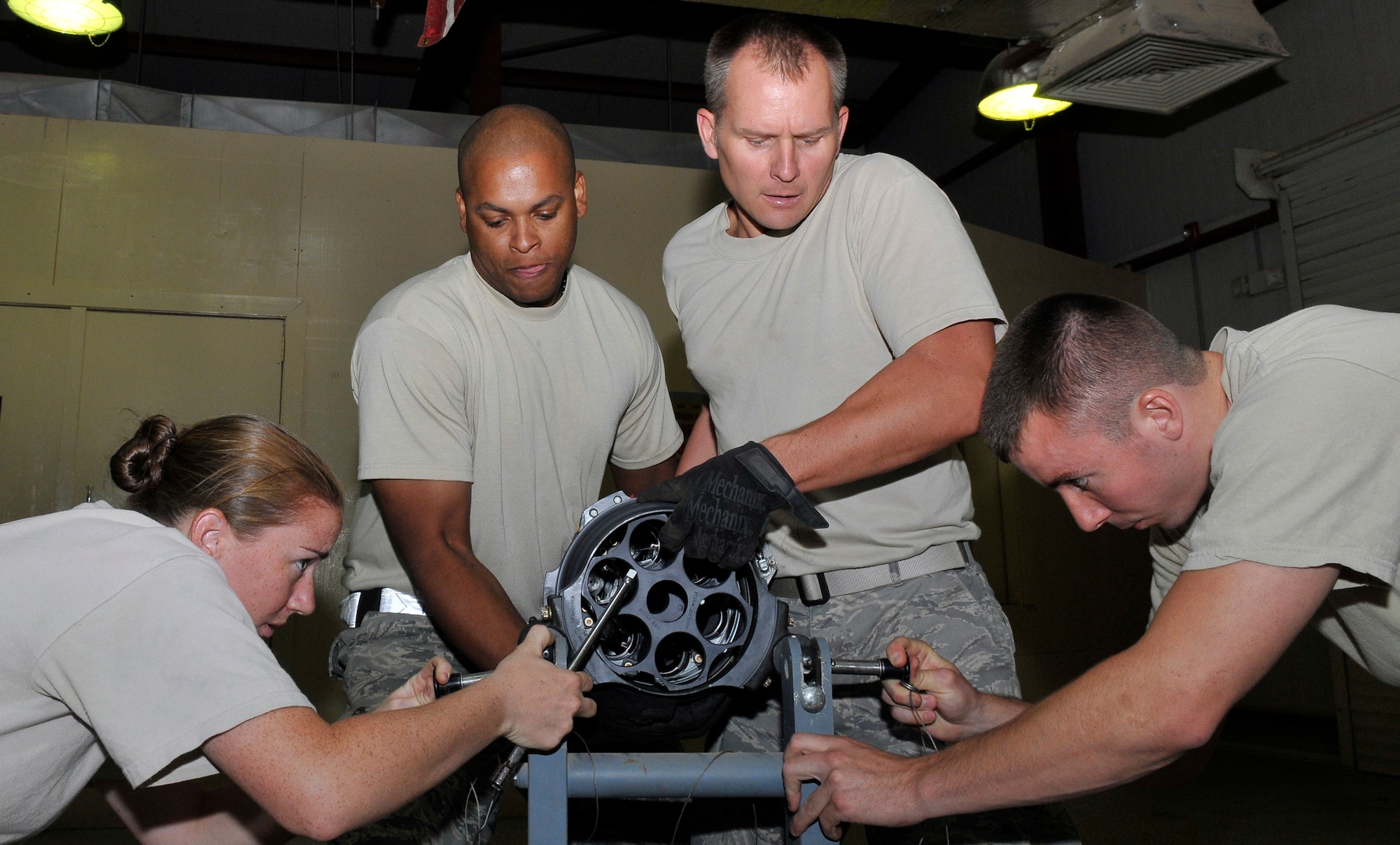 Airman 1st Class Laura Smith and Senior Airman Matthew Wilson, push large support pins into a M61A1 20mm Gatling-type gun maintenance stand as Staff Sgt. Calvin Adger and Tech. Sgt. Christopher Knackstedt hold the more than 80 pound main gun housing of the cannon Aug. 6, 2010, Joint Base Balad, Iraq. The M61A1 is a six-barreled automatic rotary weapon that can fire at a rate of 6,000 rounds per minute. Airmen Smith, Wilson and Sergeant Knackstedt are deployed from Shaw Air Force Base, S.C., Sergeant Adger is deployed from the McEntrye Air National Guard Station, S.C. All are assigned to the 332nd Expeditionary Maintenance Squadron. (U.S. Air Force photo/Staff Sgt. Phillip Butterfield)