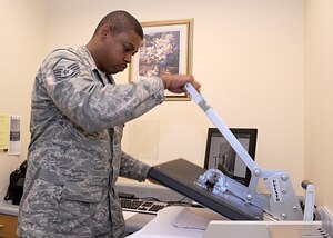 MSgt Darrius Stone, Airman and Family Readiness Center superintendent, closes the heat press to create a one-of-a-kind pillowcase at the at the AFRC.  The AFRC provides pillowcases and handbags with photos to the families of deploying servicemembers.
