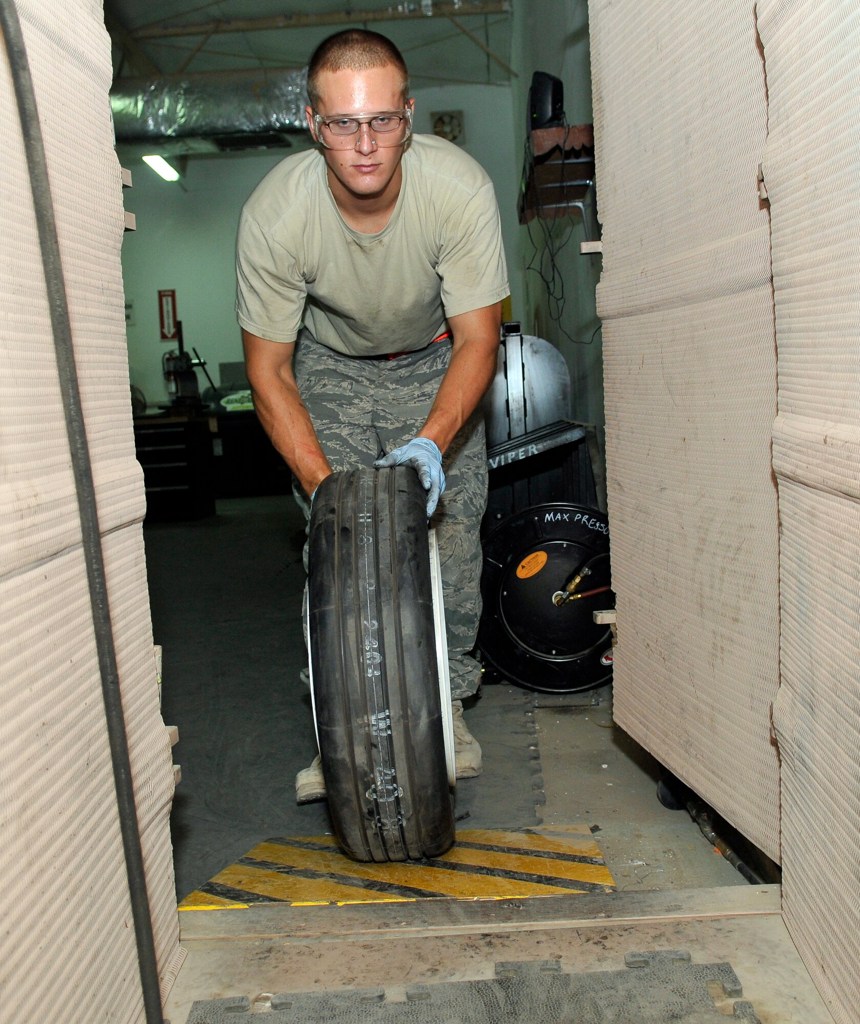 Senior Airman William Davenport, 332 Expeditionary Maintenance Squadron Crash Recovery, Wheel and Tire technician, pushes a rebuilt aircraft wheel into a tire inflation closet to fill it with Nitrogen July 9, 2010, Joint Base Balad, Iraq. The closet is used to inflate wheel to prevent injury if the wheel explodes while under pressure. Airman Davenport is a native of Trenton. Mich., deployed from McEntyre Joint National Guard Base, S.C. (U.S. Air Force photo/ Staff Sgt. Phillip Butterfield)