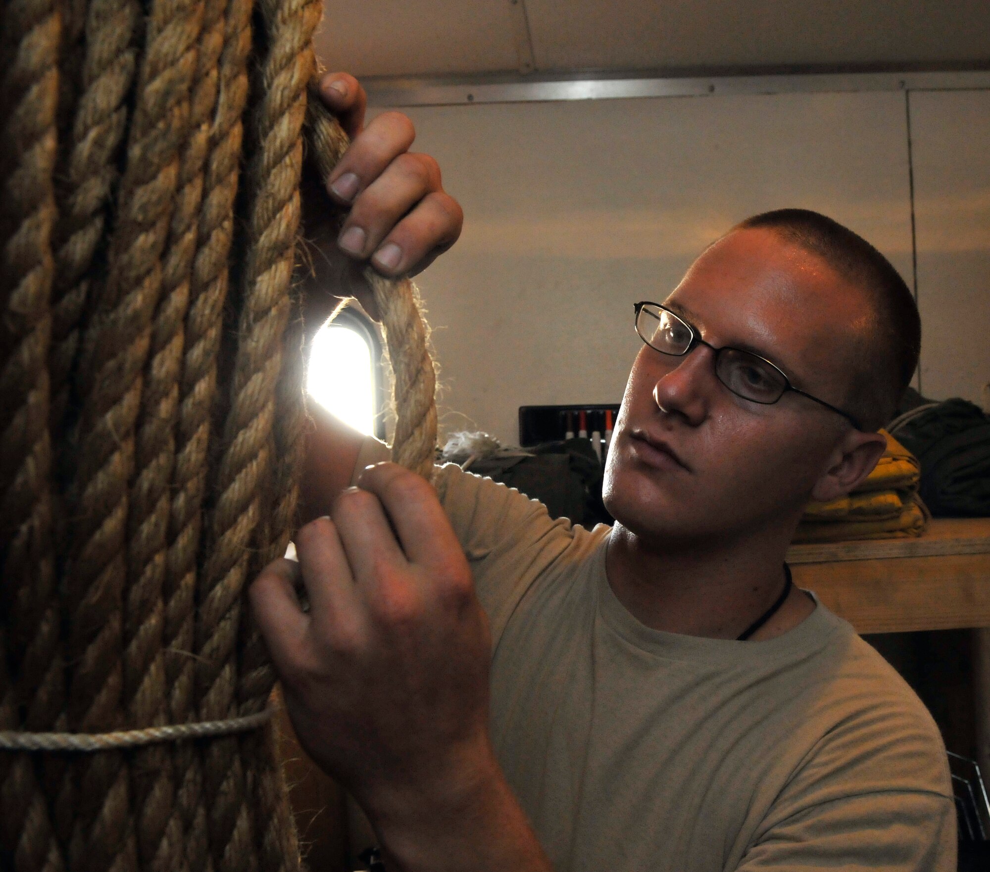 Senior Airman William Davenport, 332 Expeditionary Maintenance Squadron Crash Recovery, Wheel and Tire technician, inspects rope for serviceability July 9, 2010, Joint Base Balad, Iraq. Rope is used as guidelines when hoisting and moving damaged aircraft from the airfield. Airman Davenport is a native of Trenton. Mich., deployed from McEntyre Joint National Guard Base, S.C. (U.S. Air Force photo/ Staff Sgt. Phillip Butterfield)