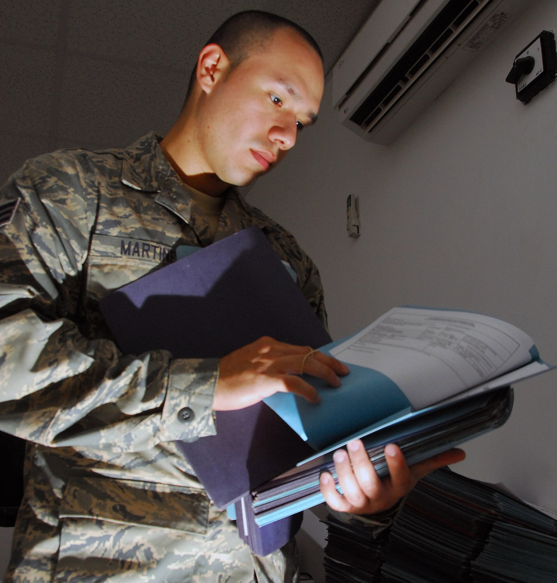 Senior Airman Max Martinez, 332nd Expeditionary Security Forces Group executive assistant, reviews awards and decoration packages Aug 6, 2010, Joint Base Balad, Iraq. Airman Martinez maintains more than 150 packages, consisting of achievement, accommodation, combat action, bronze stars and meritorious service medals. Airman Martinez is a native of Bronx, N.Y., deployed from Altus Air Force Base, Okla. (U.S. Air Force photo/Senior Airman Marianne E. Lane)