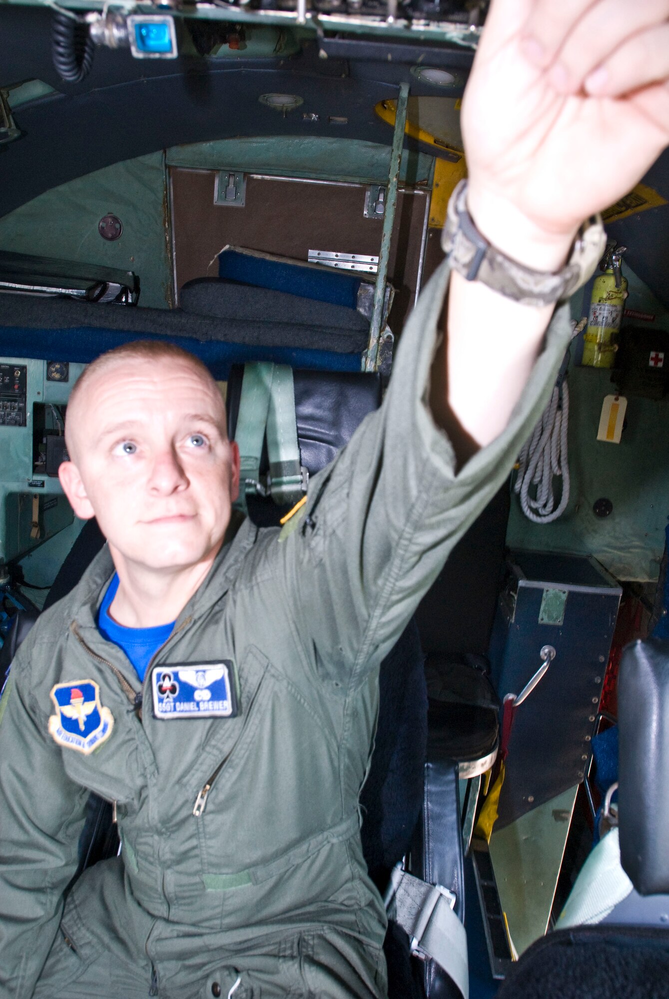 Staff Sgt. Daniel Brewer, a 62nd Airlift Squadron flight engineer instructor, demonstrates which knobs are turned for a preflight checklist inside a C-130 aircraft Aug. 6. The Logansport, Ind., native excelled in academics, taking two College Level Examination Program courses and completing two others to earn his Community College of the Air Force degree. (U.S. Air Force photo by Staff Sgt. Nestor Cruz)