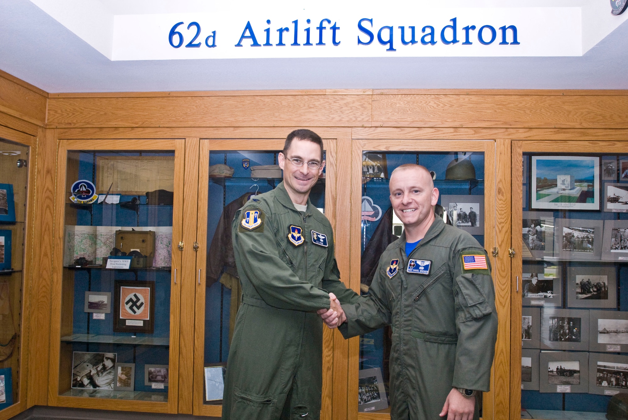 Col. C.K. Hyde, 314th Airlift Wing commander, presents a coin Aug. 6 to Staff Sgt. Daniel Brewer, a 62nd Airlift Squadron flight engineer instructor, for his selection as the Combat Airlifter of the Week. Sergeant Brewer showed dedication to fitness as the unit fitness program manager and received a rating of “excellent” on staff assisted visits from the 19th Airlift Wing and 314th Operations Group. (U.S. Air Force photo by Staff Sgt. Nestor Cruz)