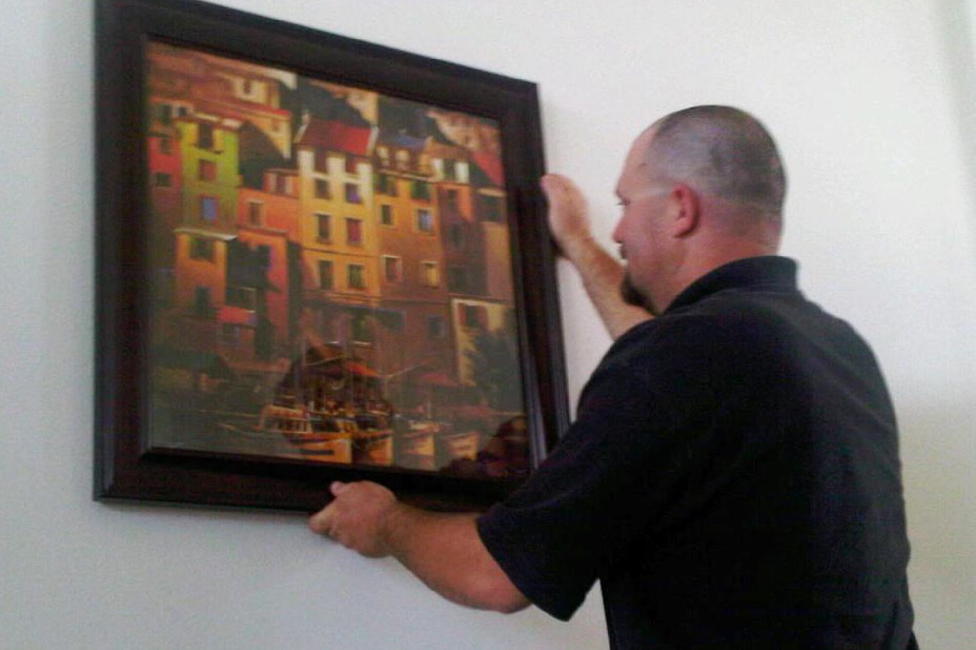 Bobby Hunt, Pinnacle maintenance supervisor, helps out a deployed spouse with hanging pictures around the house. The Landings at Goodfellow Deployed Spouses’ Program now offers assistance with honey-do items for families with a deployed servicemember such as moving furniture, hanging drapes or pictures, or even pulling weeds from a flower bed. (Courtesy photo)