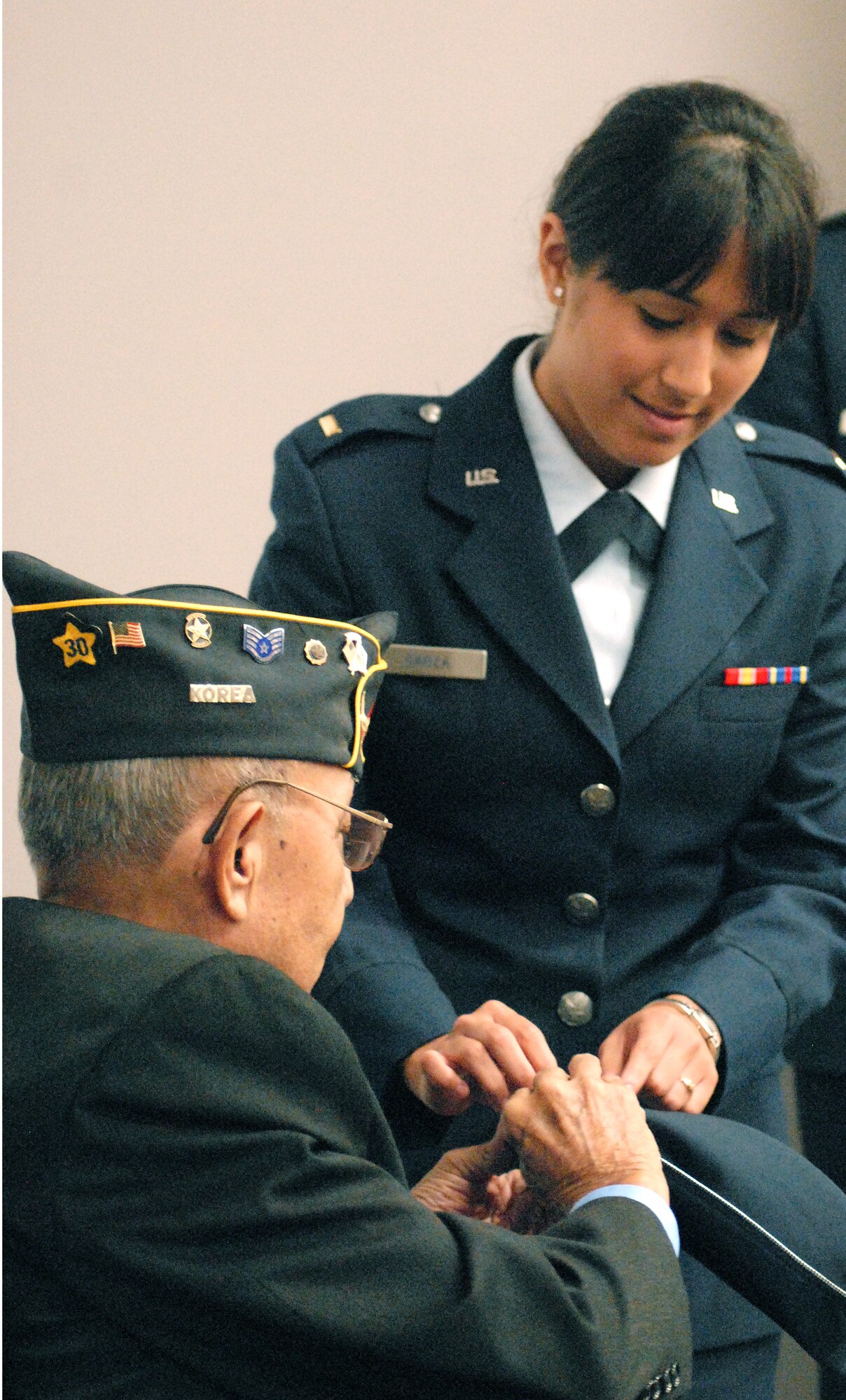 Newly commissioned 2nd Lt. Alexandria Garza helps her grandfather, Ramon Velasquez, pin her new bars on her flight cap during her commissioning ceremony at Angelo State University, San Angelo, TX August 6.  Two other cadets from the Air Force Reserve Officer Training Corps Detachment 847 received their commission as well during the ceremony. (U.S. Air Force photo/Master Sgt Randy Mallard)