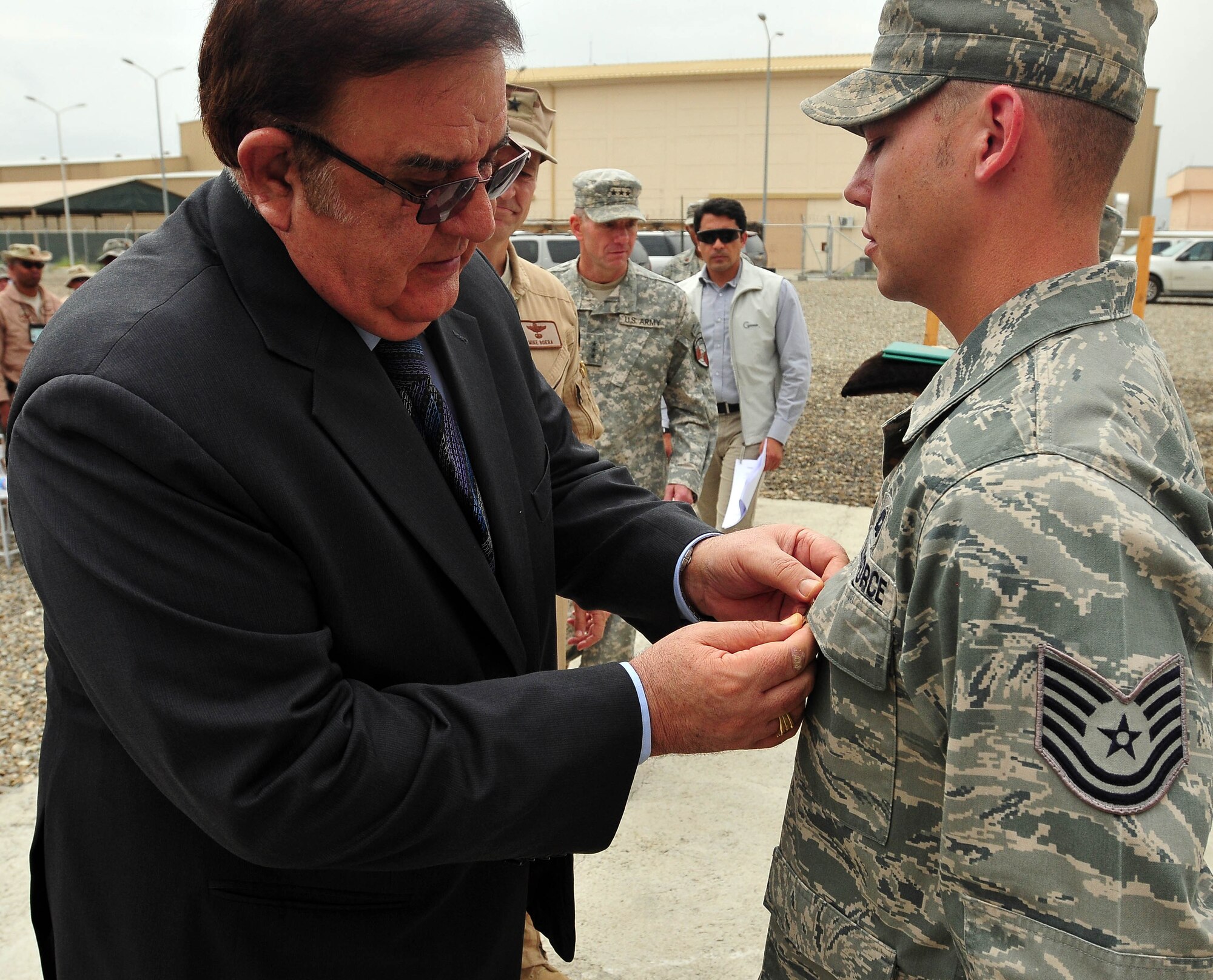 100810-N-6031Q-005 KABUL, Afghanistan - Ministry of Defense Abdul Rahim Wardak pins the Army Achievement medal to TSrgt. Robert Moore, 438th Air Expeditionary Advisery Group, during an award presentation held at the Afghan Air Force base in Kabul, Afghanistan on Aug. 10, 2010. The award presentation was in recognition of U.S. Air Force Airmen who have had a significant impact on the CAPTF mission in Afghanistan over the last several months. (US Navy photo by Mass Communication Specialist 2nd Class David Quillen/ RELEASED).