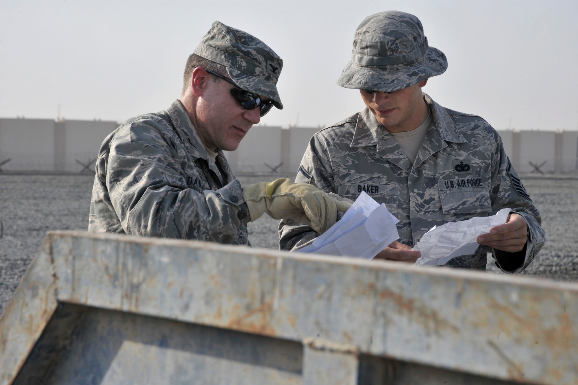 Col. Mark Danigole, 380th Air Expeditionary Wing vice commander, and Master Sgt. Joseph Baker III, 380th Air Expeditionary Wing antiterrorism superintendent,  review papers found in a dumpster Aug. 8 at an undisclosed location in Southwest Asia.  All paper and sticky notes, whether written on or not , address labels, customs forms, duty rosters, manning rosters, anything talking about aircraft, and anything written about aircraft, and anything with your name or unit must be shredded. The only paper products that can we thrown away here are food wrappers if not written on, newspapers and magazines with the mailing address removed. (U.S. Air Force photo/Tech. Sgt. April Wickes)