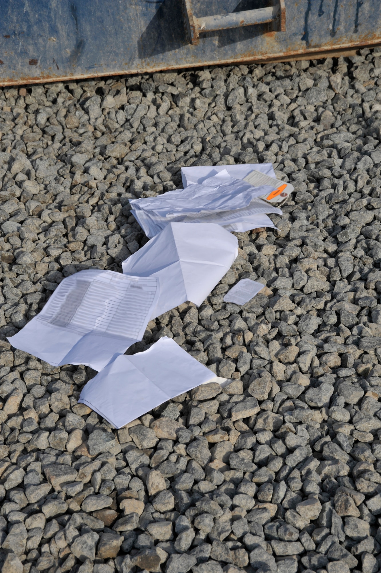Documents found by members of the 380th Air Expeditionary Wing antiterrorism office and Col. Mark Danigole, 380th Air Expeditionary Wing vice commander, rest on the ground Aug. 8 at an undisclosed location in Southwest Asia.  All paper and sticky notes, whether written on or not , address labels, customs forms, duty rosters, manning rosters, anything written about aircraft, and anything with your name or unit must be shredded. The only paper products that can we thrown away here are food wrappers if not written on, newspapers and magazines with the mailing address removed. (U.S. Air Force photo/Tech. Sgt. April Wickes)