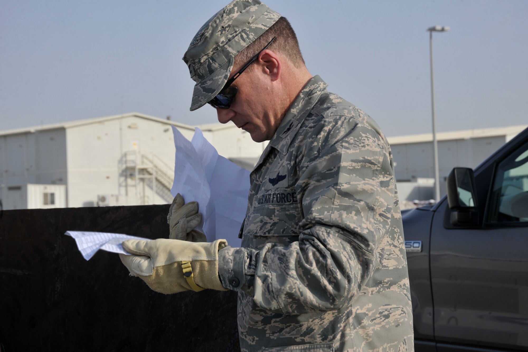 Col. Mark Danigole, 380th Air Expeditionary Wing vice commander, reviews paper found in a dumpster Aug. 8 at an undisclosed location in Southwest Asia.  All paper and sticky notes, whether written on or not , address labels, customs forms, duty rosters, manning rosters, anything talking about aircraft, and anything written about aircraft, and anything with your name or unit must be shredded. The only paper products that can we thrown away here are food wrappers if not written on, newspapers and magazines with the mailing address removed. (U.S. Air Force photo/Tech. Sgt. April Wickes)