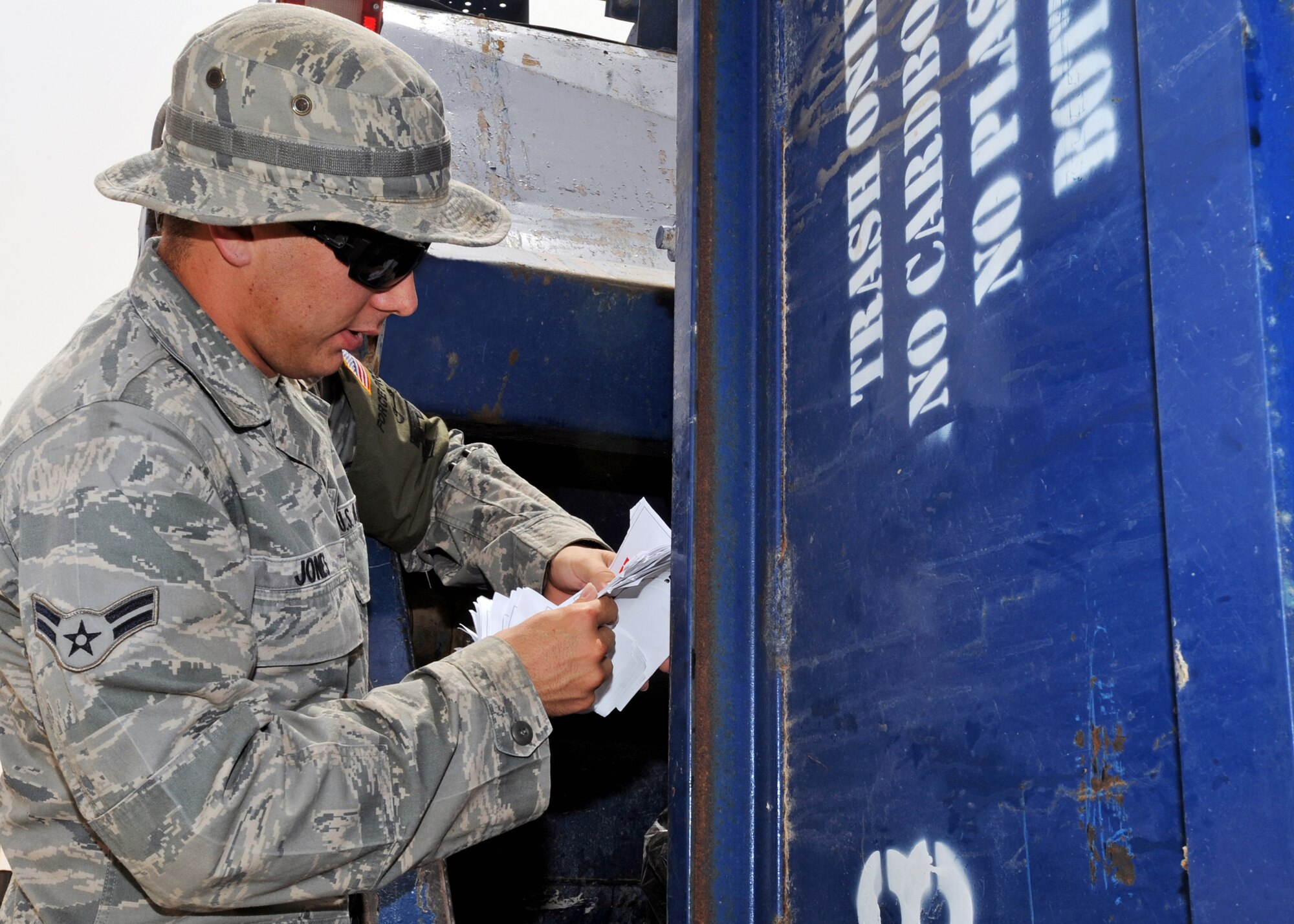 SOUTHWEST ASIA - Airman 1st Class Robert Jones, 386th Expeditionary Civil Engineer Squadron Force Protection escort, looks for discarded classified documents and other sensitive material in a trash bin here July 22, 2010. Airman Jones is one of approximately 100 Force Protection escorts assigned to the 386th ECES/FP. (U.S. Air Force photo by Senior Airman Laura Turner)