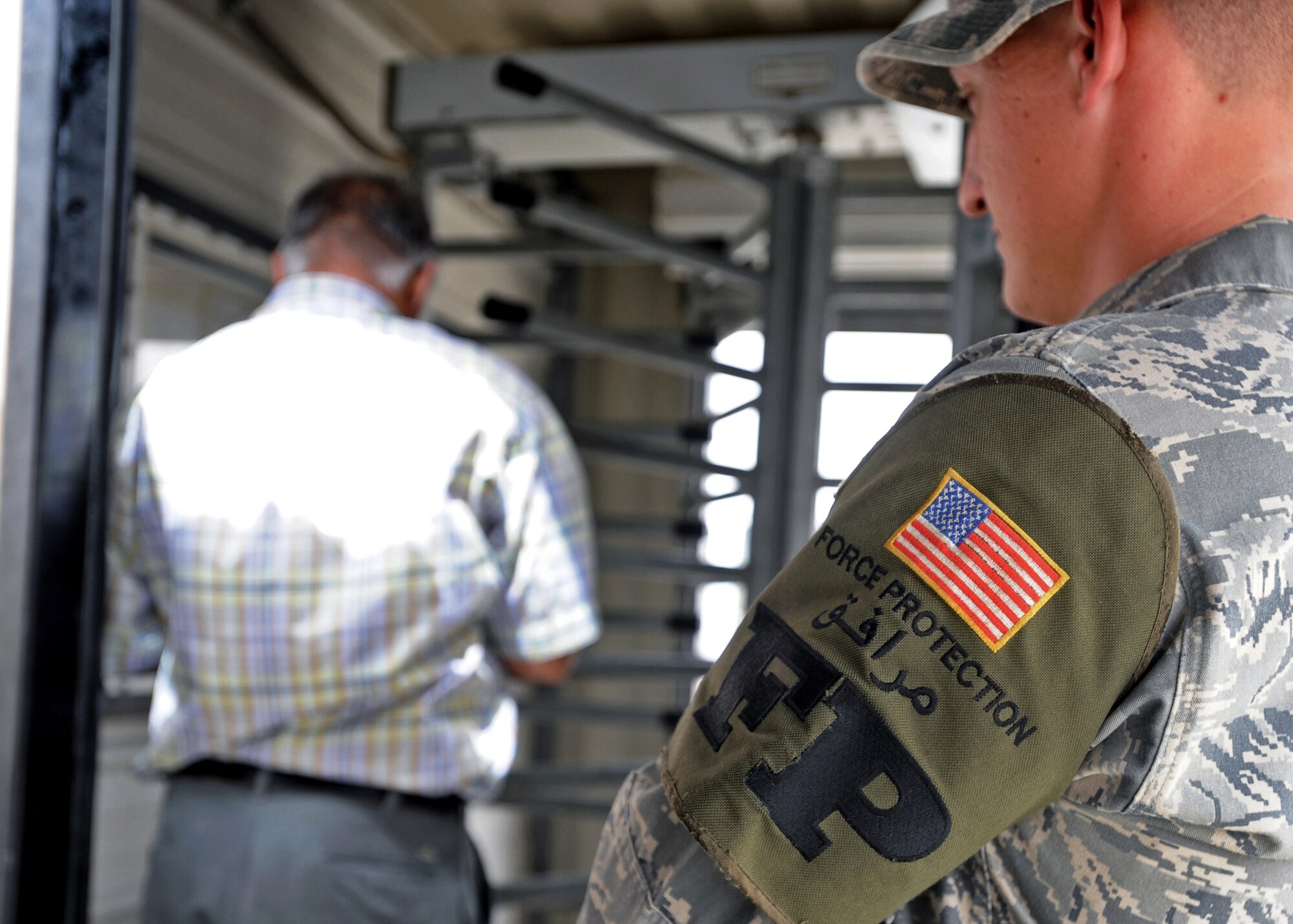 SOUTHWEST ASIA - Airman 1st Class Kenneth Silk, 386th Expeditionary Civil Engineer Squadron Force Protection escort, keeps an eye on a third-country national as he in-processes to the base here July 22, 2010. Airman Silk is one of approximately 100 Force Protection escorts assigned to the 386th ECES/FP. (U.S. Air Force photo by Senior Airman Laura Turner)