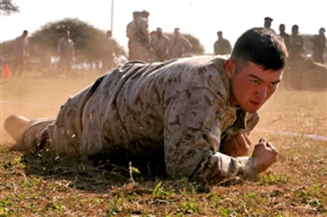 A U.S. Marine low crawls during the Marine Combat Fitness Test in Moamba, Mozambique, Aug. 6, 2010. Marines ran the fitness test during Exercise Shared Accord 2010 to demonstrate it to soldiers of the Armed Forces for the Defense of Mozambique. The exercise is an annually scheduled, bi-lateral field training exercise aimed at conducting small unit infantry and staff training with U.S. Africa Command partner nations.