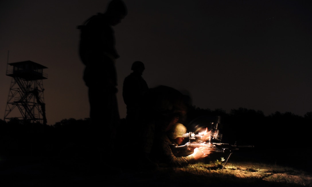 A Marine with Company A, Marine Barracks Washington, loads his Squad Automatic Weapon (SAW) during a night shot Aug. 9 on an unkown distance course at Marine Corps Base Quantico, Va.