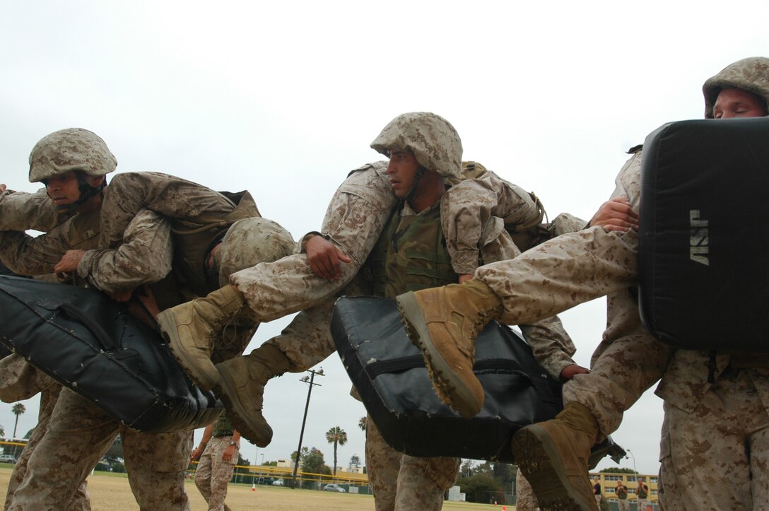Staff Sgt. Antonio Gomez, drill instructor, Company H, 2nd Battalion, Recruit Training Regiment, center, and Sgt. David Chavez, Osprey Mechanic, Marine Medium Tiltrotor Squadron-161, left, attempt to keep in line with their squad mates during the fireman carry.