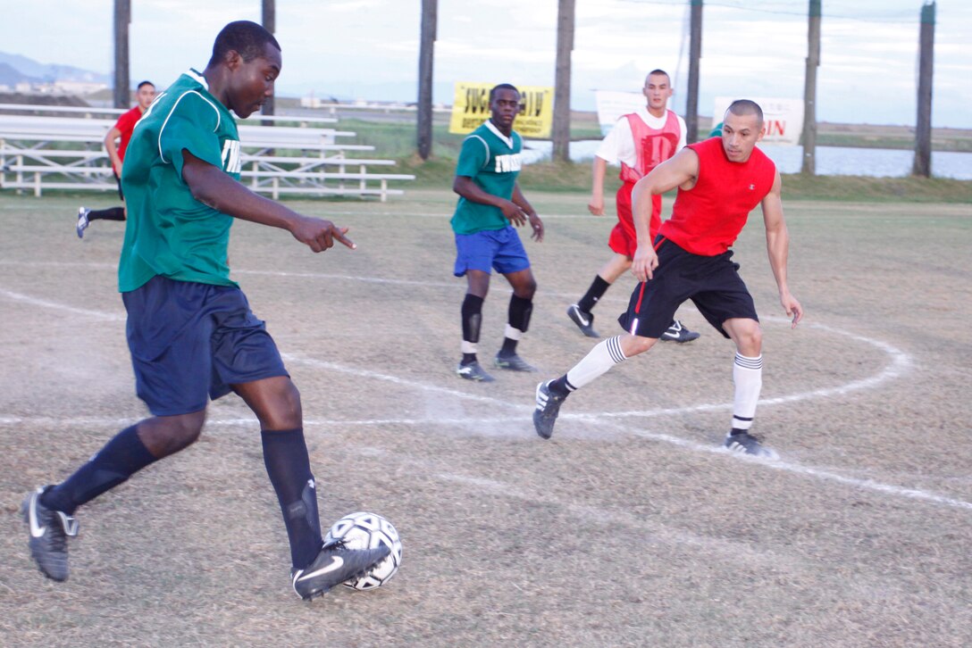 Patrick Manu, forward for the Legends, takes the ball up the field during an intramural soccer game against Marine Wing Support Squadron 171 at the Penny Lake soccer field here Aug. 10. Despite MWSS-171 maintaining its lead for almost the entire game, the Legends players were ultimately able to tie the match 4-4.