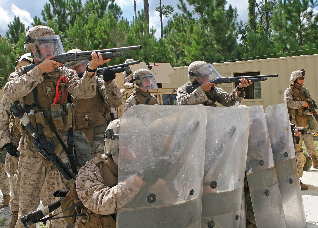 Marines of 5th Platoon, Company C, Marine Corps Security Forces Regiment, II Marine Expeditionary Force, stationed out of Naval Station Norfolk, Va., stand ready to oppose a simulated hostile force using non-lethal weapons and tactics at the Movement on Urban Terrain facilities aboard Marine Corps Base Camp Lejeune, N.C., Aug. 10, 2010.  During a five-day mission readiness exercise, the Marines were evaluated on how they employed the different skill sets they have been taught during the past nine months in preparation for a seven-month deployment to Bahrain.