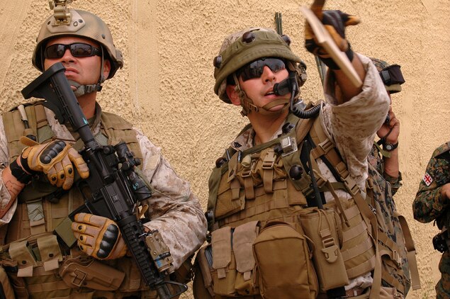 Master Sgt. Hector Reyes {LEFT}, team chief, Georgia Liaison Team, and Sgt. Christopher Holm examine the rooftop of a building in a simulated Afghanistan village. Both Marines are with 2d Air Naval Gunfire Liaison Company and are assisting with training the Georgian 32nd Light Infantry Battalion. The 32nd Light Infantry Battalion is the second of four battalions to undergo training through the Georgia Deployment Program, a Marine Corps-led initiative designed to prepare the Georgians for their upcoming Afghanistan deployment in support of International Security Assistance Forces there.