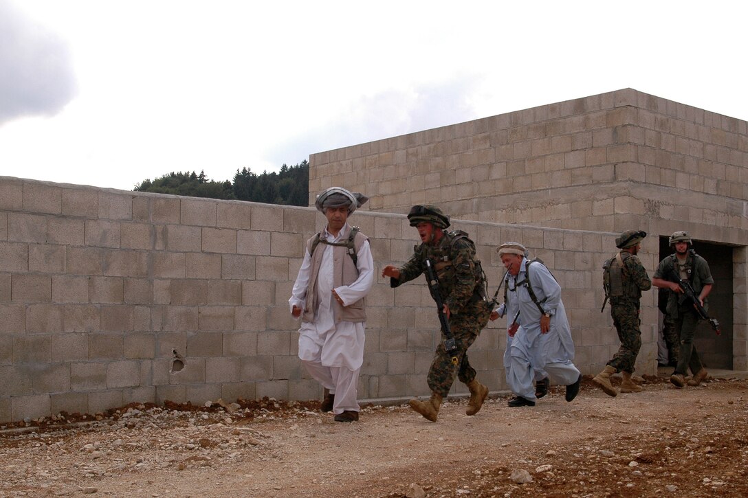 A Georgian soldiers evacuates non-hostile civilian from a building in a simulated Afghanistan village at the Joint Multinational Readiness Center here. The Republic of Georgia's 32nd Light Infantry Battalion was conducting cordon searches during their situational training exercise (STX). The STX is the first part of the mission rehearsal exercise, a final evaluation of the 32nd Battalion as they prepare for their deployment to Afghanistan in support of International Security Assistance Forces there.