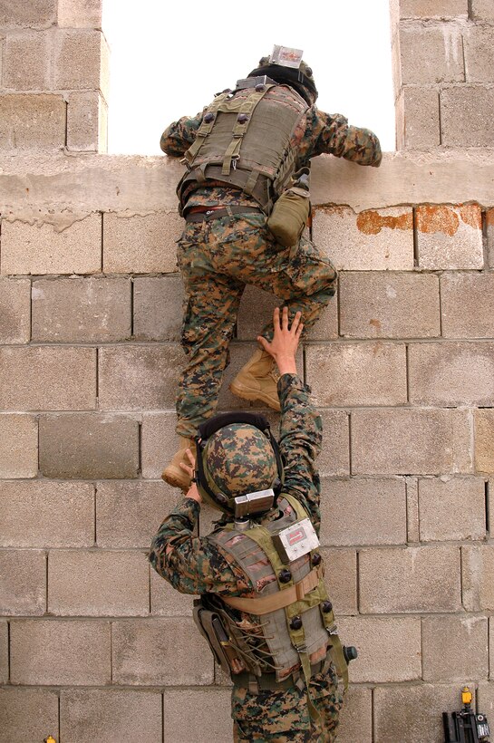 Two Georgian soldiers inch their way to the rooftop of a building in a simulated Afghanistan village. The Republic of Georgia's 32nd Light Infantry Battalion was conducting cordon searches during their situational training exercise (STX). The STX is the first part of the mission rehearsal exercise, a final evaluation of the 32nd Battalion as they prepare for their deployment to Afghanistan in support of International Security Assistance Forces there.