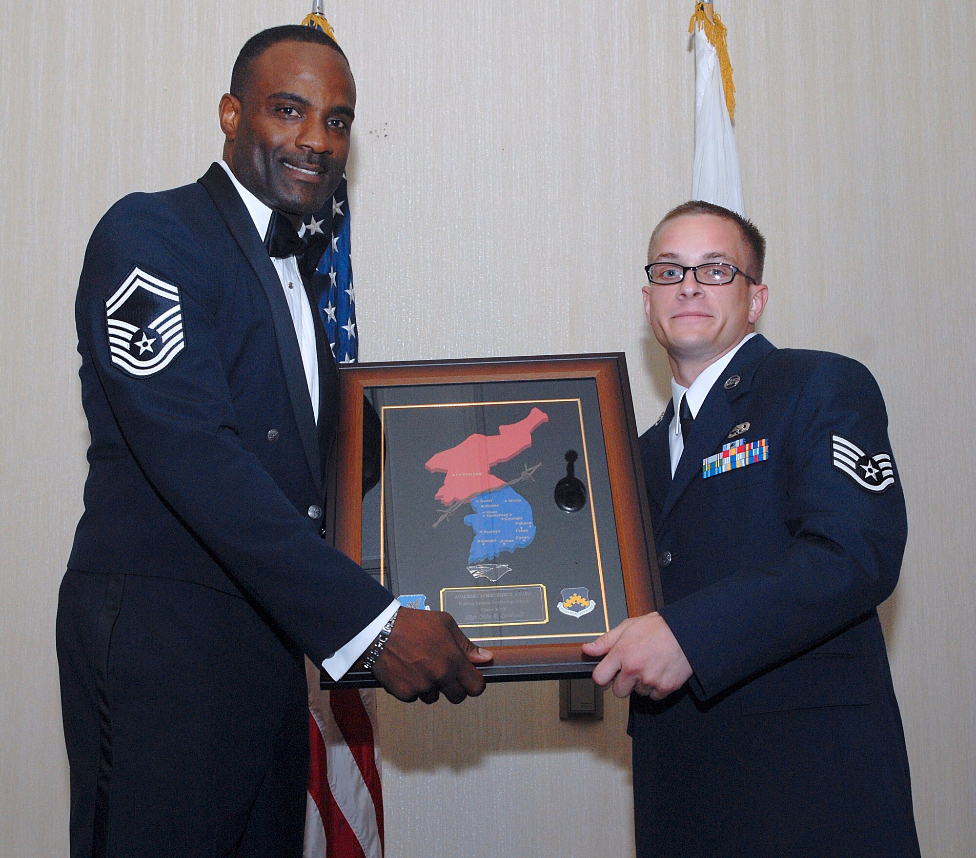 KUNSAN AIR BASE, Republic of Korea -- Senior Master Sgt. Jerome Sydnor, 8th Aircraft Maintenance Squadron weapons superintendent, presents Staff Sgt. Colin Cardwell, 8th Maintenance Squadron, with the Academic Achievement Award during the Kunsan Airman Leadership School Class 10-K graduation here Aug. 6. Sergeant Cardwell was also named a Distinguished Graduate. The class was the first at Kunsan in six years. (U.S. Air Force photo/Senior Airman Roy Lynch)