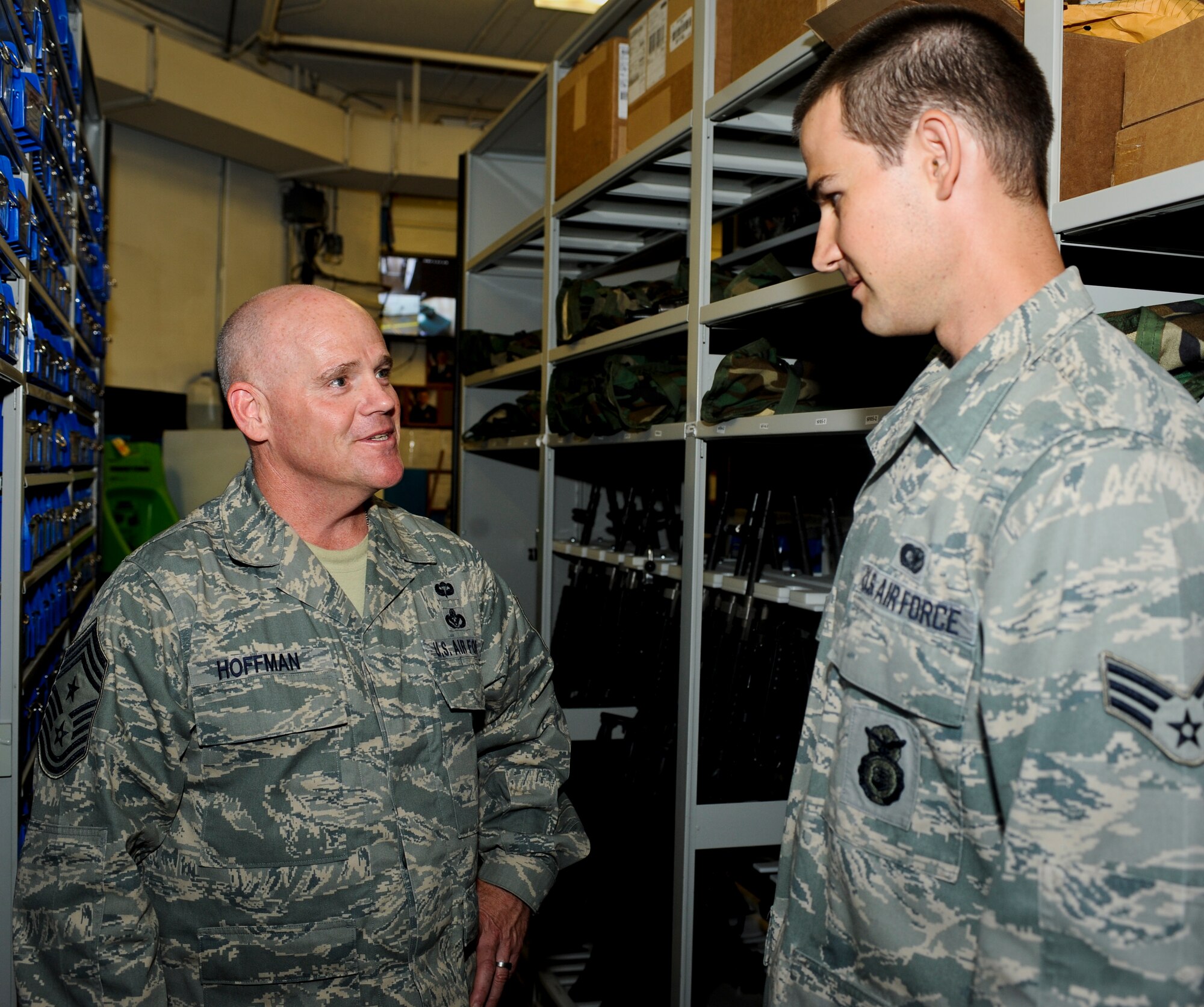 MINOT AIR FORCE BASE, N.D. -- Chief Master Sgt. John L. Hoffman, 91st Missile Wing command chief, talks with Senior Airman Steven Boatright, 91st Security Support Squadron armorer, about his duties in the armory here Aug. 11. Chief Hoffman has taken over the reigns as the new 91st MW command chief and has the welfare of his Airmen as a number one priority. The chief is visiting various units around base to get to know both the Rough Riders and Warbirds of Minot AFB. (U.S. Air Force photo by Senior Airman Benjamin Stratton)