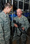MINOT AIR FORCE BASE, N.D. -- Chief Master Sgt. John L. Hoffman, 91st Missile Wing command chief, talks with Senior Airman Steven Boatright, 91st Security Support Squadron armorer, about his duties in the armory here Aug. 11. Chief Hoffman has taken over the reigns as the new 91st MW command chief and has the welfare of his Airmen as a number one priority. The chief is visiting various units around base to get to know both the Rough Riders and Warbirds of Minot AFB. (U.S. Air Force photo by Senior Airman Benjamin Stratton)