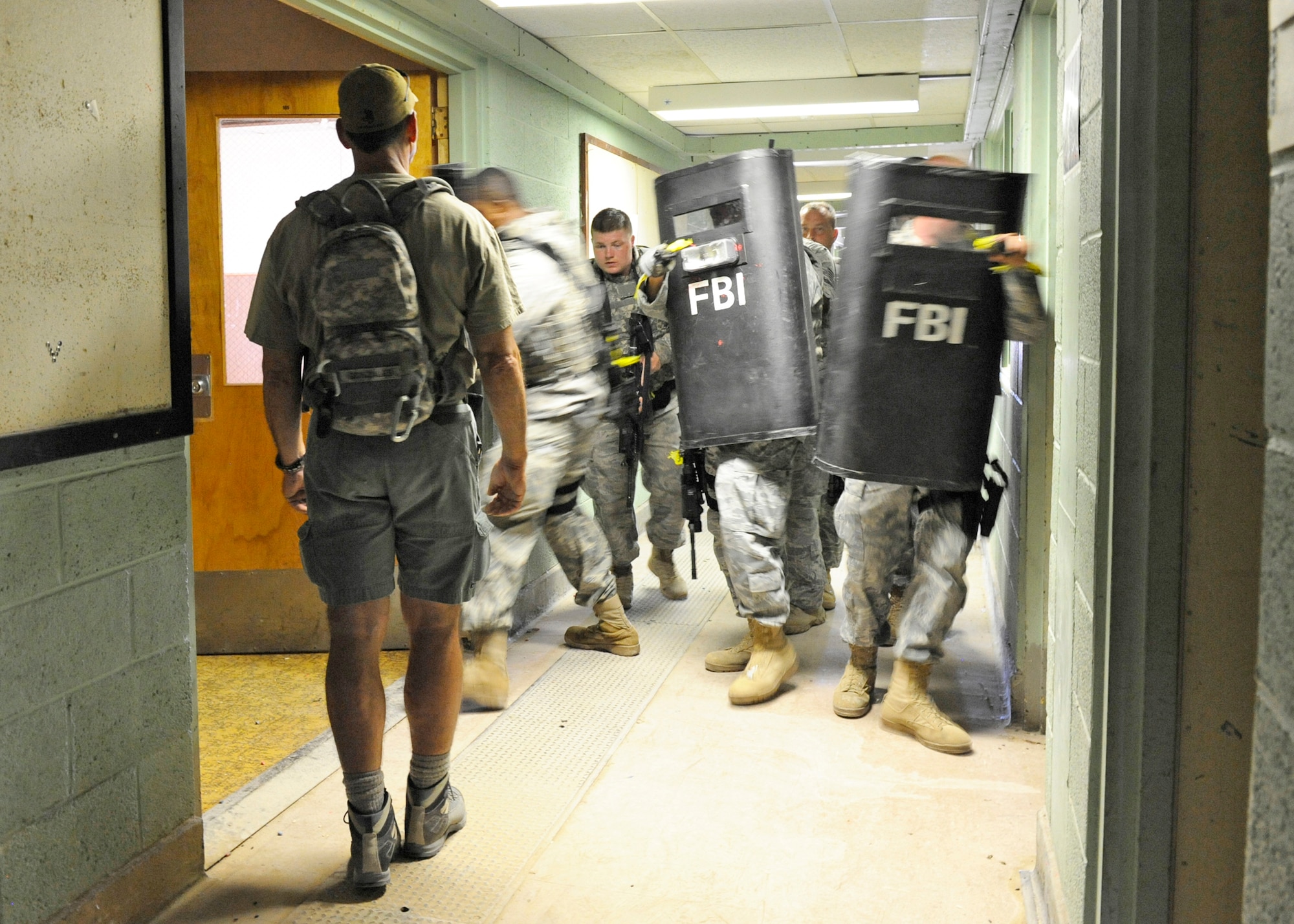 Special Agent Raymond Gonzales oversees members of the 49th Security Forces Squadron as they practice close-quarter battle and ballistic shield work during training Aug. 6, 2010, at Holloman Air Force Base, N.M. Members of the FBI helped Holloman AFB Airmen practice techniques that could be used in a real-world crisis situation. Agent Gonzales is a training coordinator with the Federal Bureau of Investigation, Albuquerque division. (U.S. Air Force photo/Airman 1st Class Eileen Payne)
