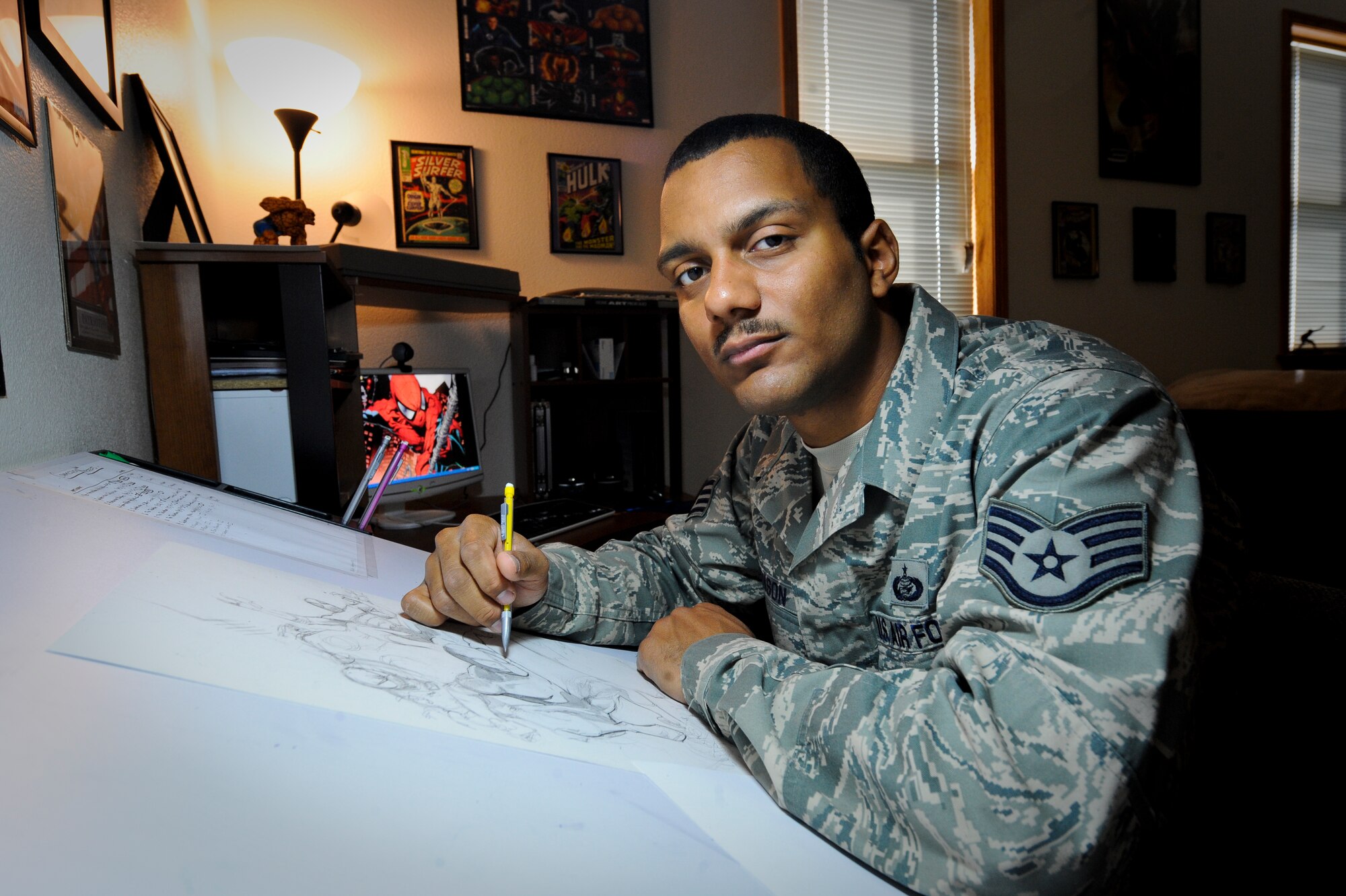 MINOT AIR FORCE BASE, N.D. -- Staff Sgt. Eric Henson, 5th Force Support Squadron base personnel reliability program monitor, poses for a picture next to his sketch of Marvel comics “Spiderman” in his home here Aug. 11. Sergeant Henson has been a comic artist since he was five years old when his father gave him a “Silver Surfer” comic book. (U.S. Air Force photo by Senior Airman Benjamin Stratton)