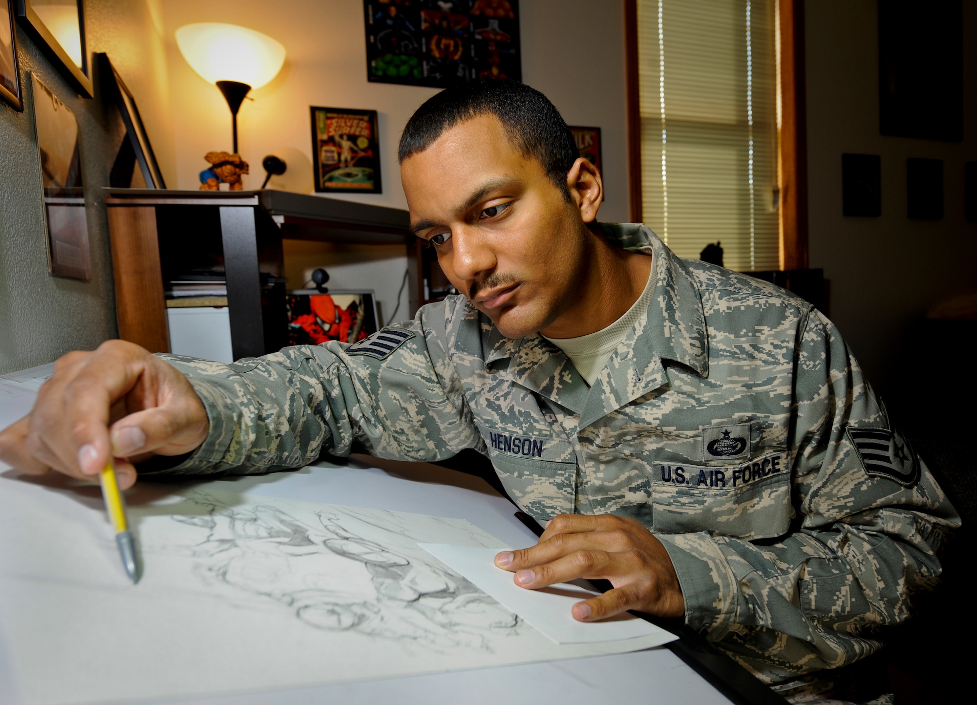 MINOT AIR FORCE BASE, N.D. -- Staff Sgt. Eric Henson, 5th Force Support Squadron base personnel reliability program monitor, works on a sketch of Marvel comics “Spiderman” in his home here Aug. 11. Sergeant Henson has been a comic artist since he was five years old when his father gave him a “Silver Surfer” comic book. (U.S. Air Force photo by Senior Airman Benjamin Stratton)