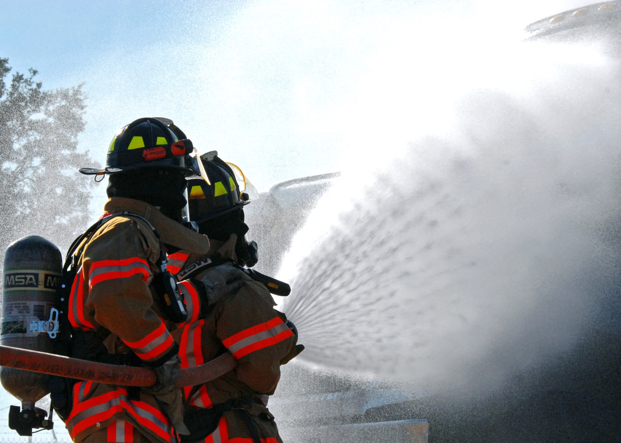 Firefighters from the 96th Civil Engineer Squadron douse a simulated truck fire during a Nuclear Accident Response Exercise Aug. 11 at Eglin Air Force Base, Fla.  This exercise assessed the ability of base personnel to support a request from Department of Energy  and respond to a major accident. In the scenario, while securing the vehicles from a DoE convoy, the DoE truck experienced an engine fire and two DoE personnel suffered severe burns while trying to extinguish the fire. Emergency personnel responded to the situation, secured the scene, transported the victims and put out the fire.  (U.S. Air Force photo/Samuel King Jr.)