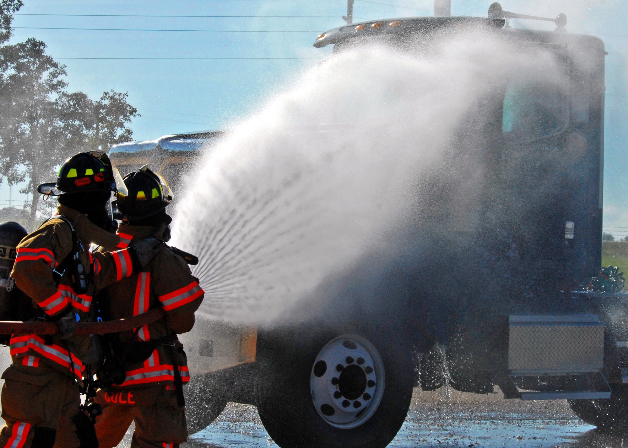Firefighters from the 96th Civil Engineer Squadron douse the simulated truck fire during Nuclear Accident Response Exercise Aug. 11 at Eglin Air Force Base, Fla.  This exercise assessed the ability of base personnel to support a request from Department of Energy  and respond to a major accident. In the scenario, while securing the vehicles from a DoE convoy, the DoE truck experienced an engine fire and two DoE personnel suffered severe burns while trying to extinguish the fire. Emergency personnel responded to the situation, secured the scene, transported the victims and put out the fire.  (U.S. Air Force photo/Samuel King Jr.)